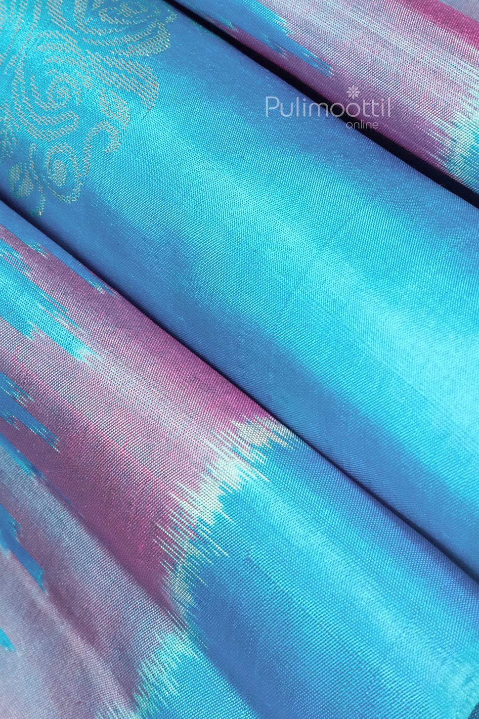 Detailed shot of a blue and pink gradient Kanchipuram silk saree with traditional Ikat design and rich golden zari work, showcasing premium handloom craftsmanship.