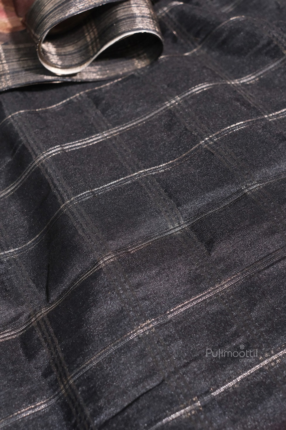 Back view of a woman in a black semi tussar silk saree, highlighting the elegant fall and smooth finish of the fabric.