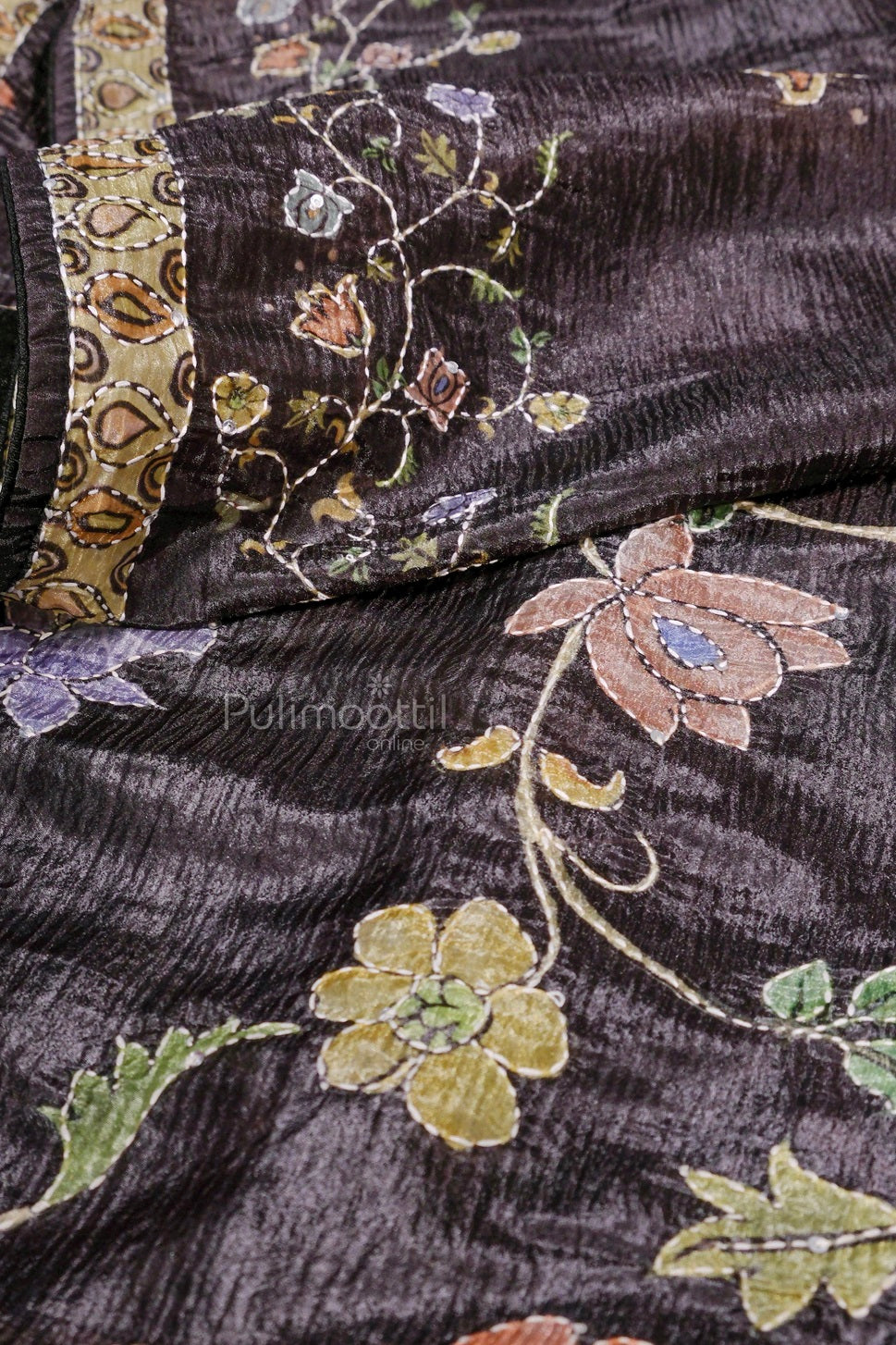 Black silk saree with multicolored floral embroidery and an ornate border, neatly folded to display the design.