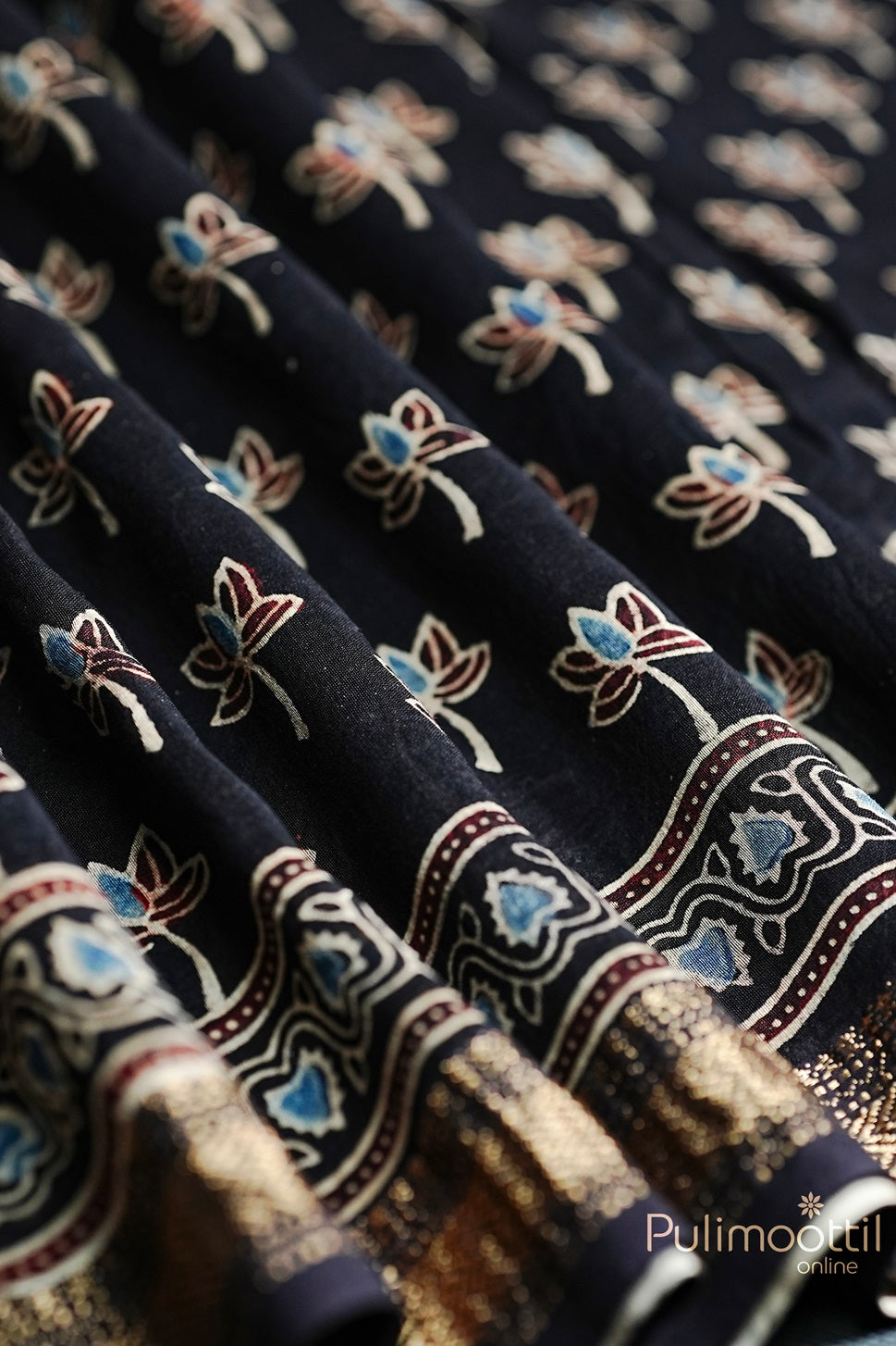 Close-up of Black Colour Chandheri Silk Saree with vibrant floral block print and intricate zari zig-zag border.