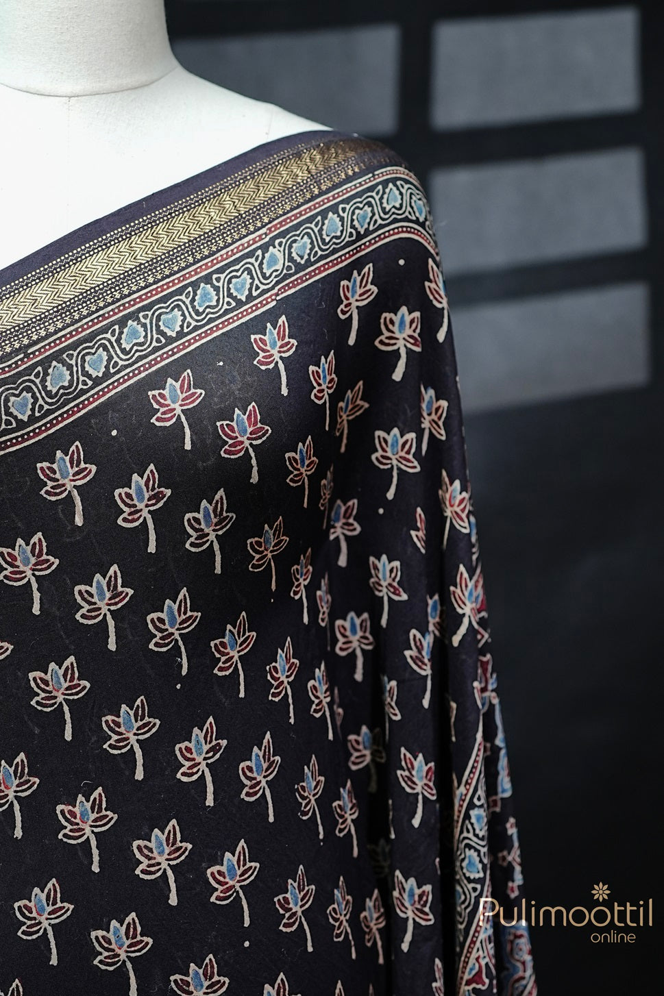 Black Colour Chandheri Silk Saree draped, featuring floral block print and intricate zari zig-zag border with rich detailing.