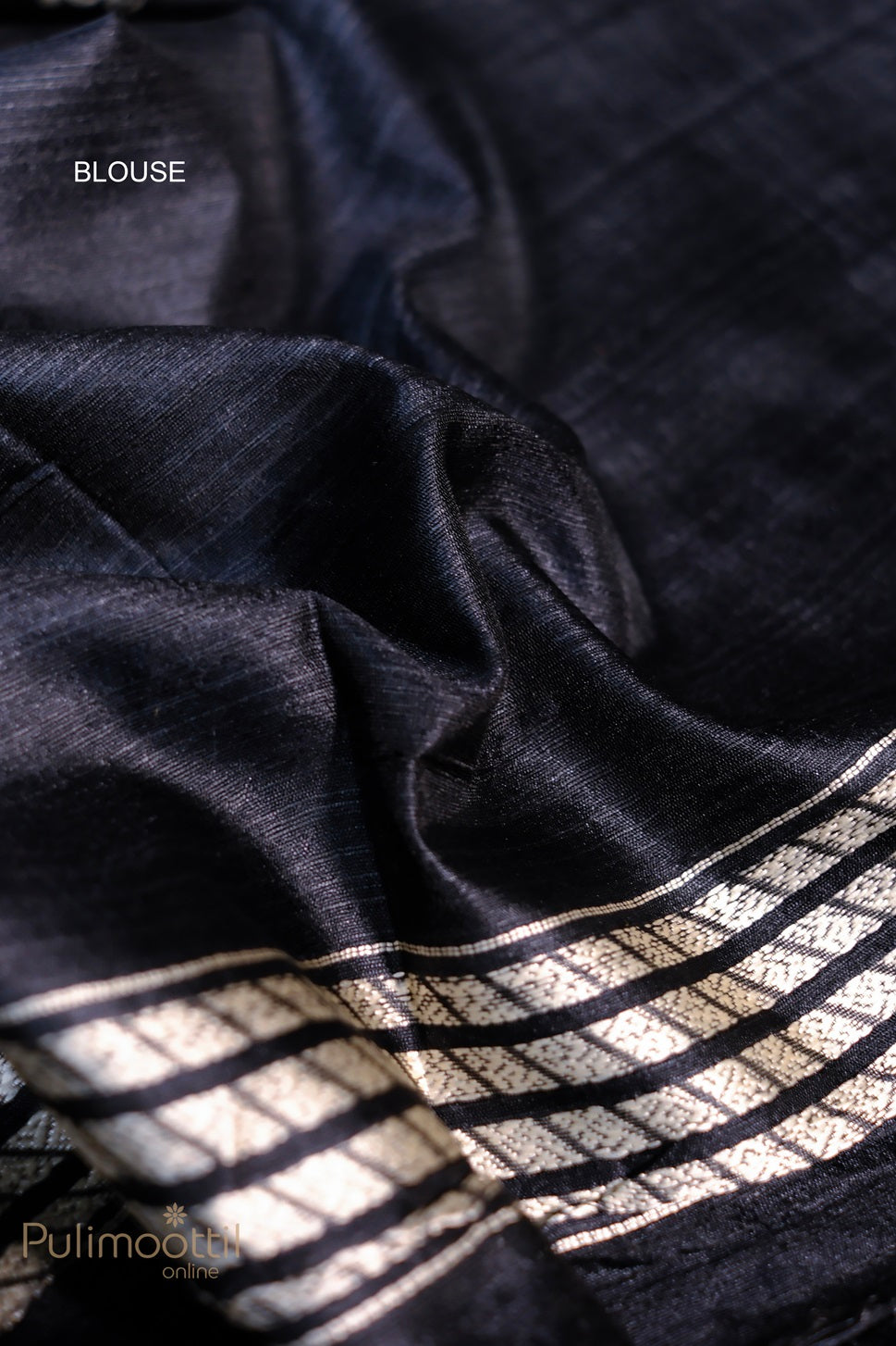 Close-up of the black saree fabric highlighting the silver striped border and intricate thread work with tribal designs, offering a traditional and sophisticated look.