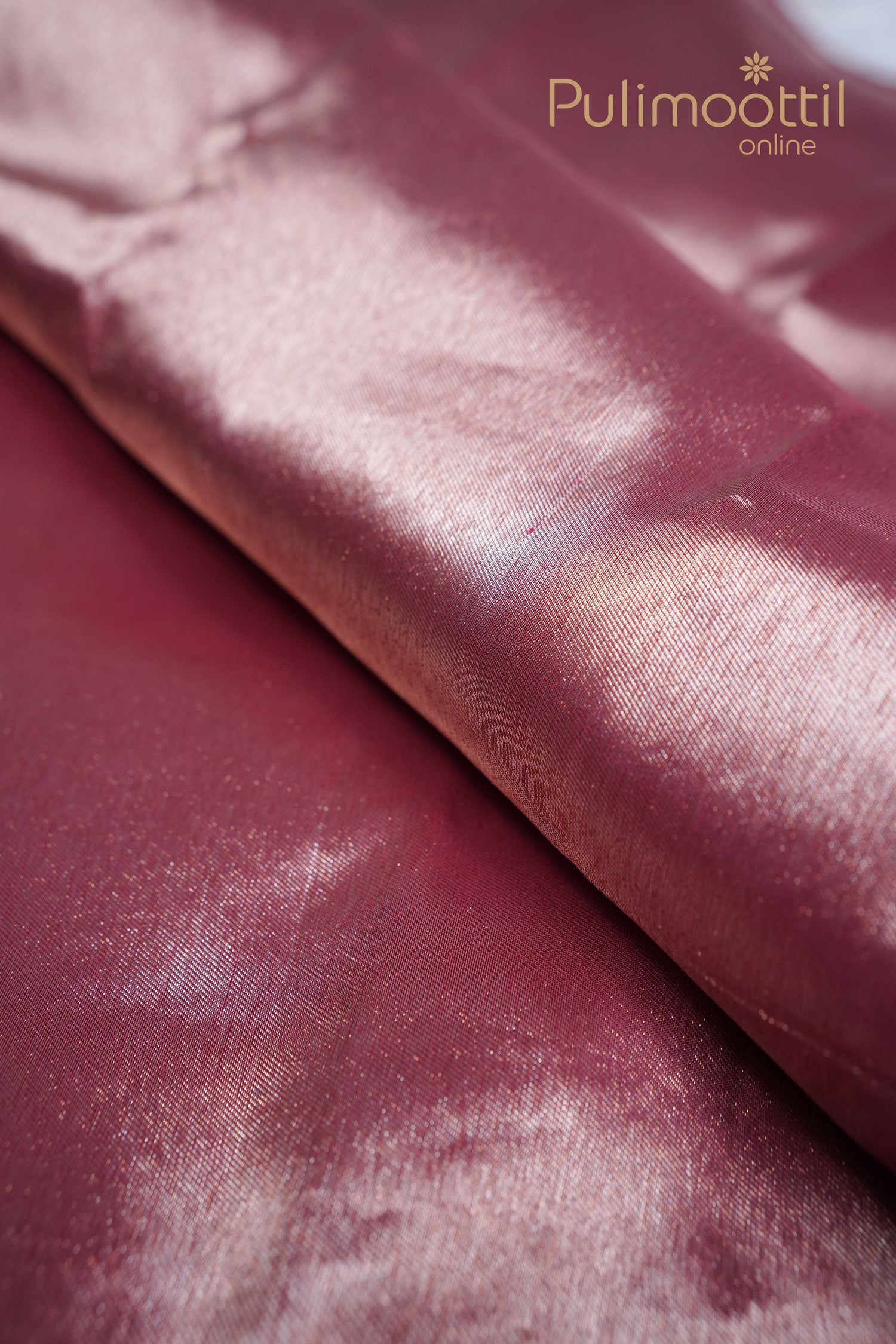 Glossy maroon Kanchipuram silk saree with lustrous finish and soft texture, showcasing elegant light reflections – perfect for bridal and festive wear.