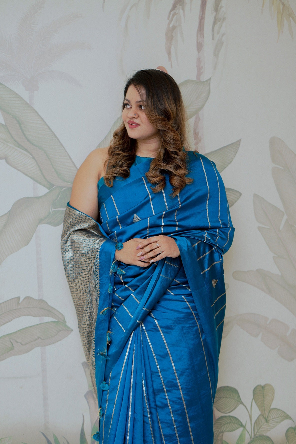 Woman in a pure Benarasi mango silk saree in turquoise blue, styled for bridal or party wear occasions, shop online.
