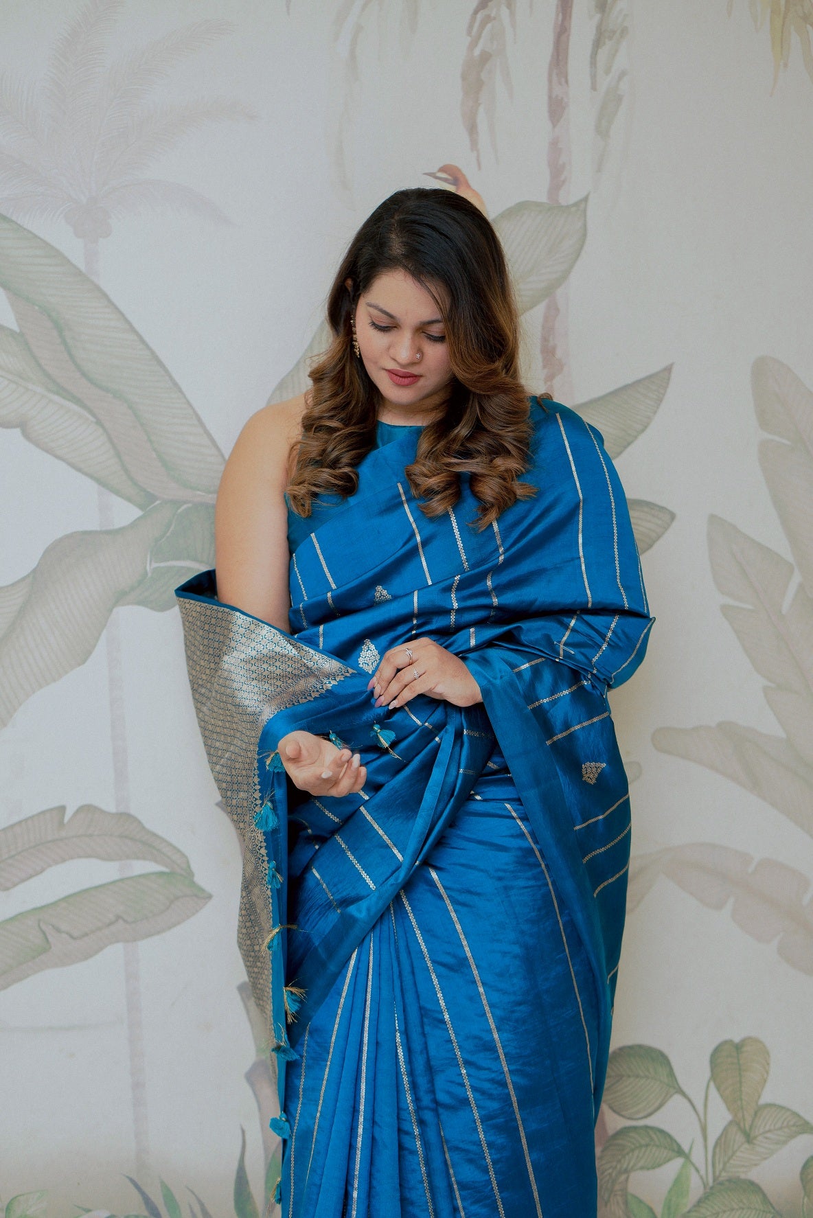 Woman draped in a buttery soft turquoise blue Benarasi bridal saree in mango silk, perfect for party wear and available online.