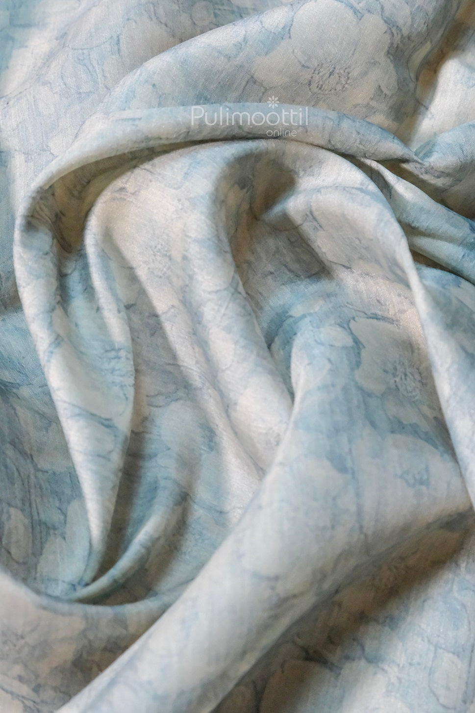 Pastel blue blouse fabric with soft floral print and smooth texture, ideal for pairing with designer sarees.