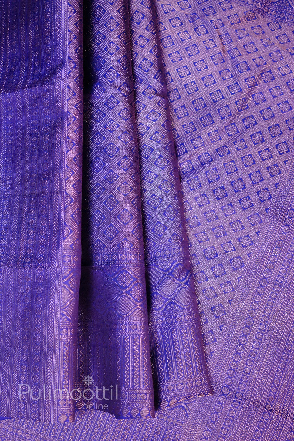 Draped royal purple Kanchipuram silk saree with dense gold-zari micro-motif weave and soft sheen.