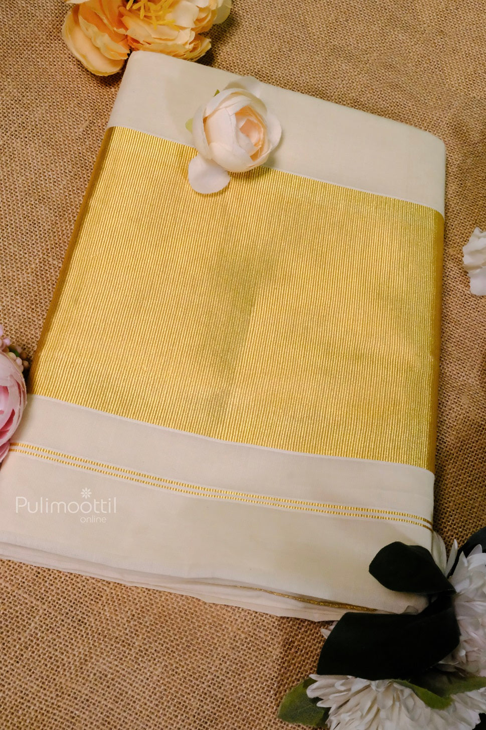 Elegant cream Kerala saree with golden zari border, neatly folded with pink and white flowers on a burlap background