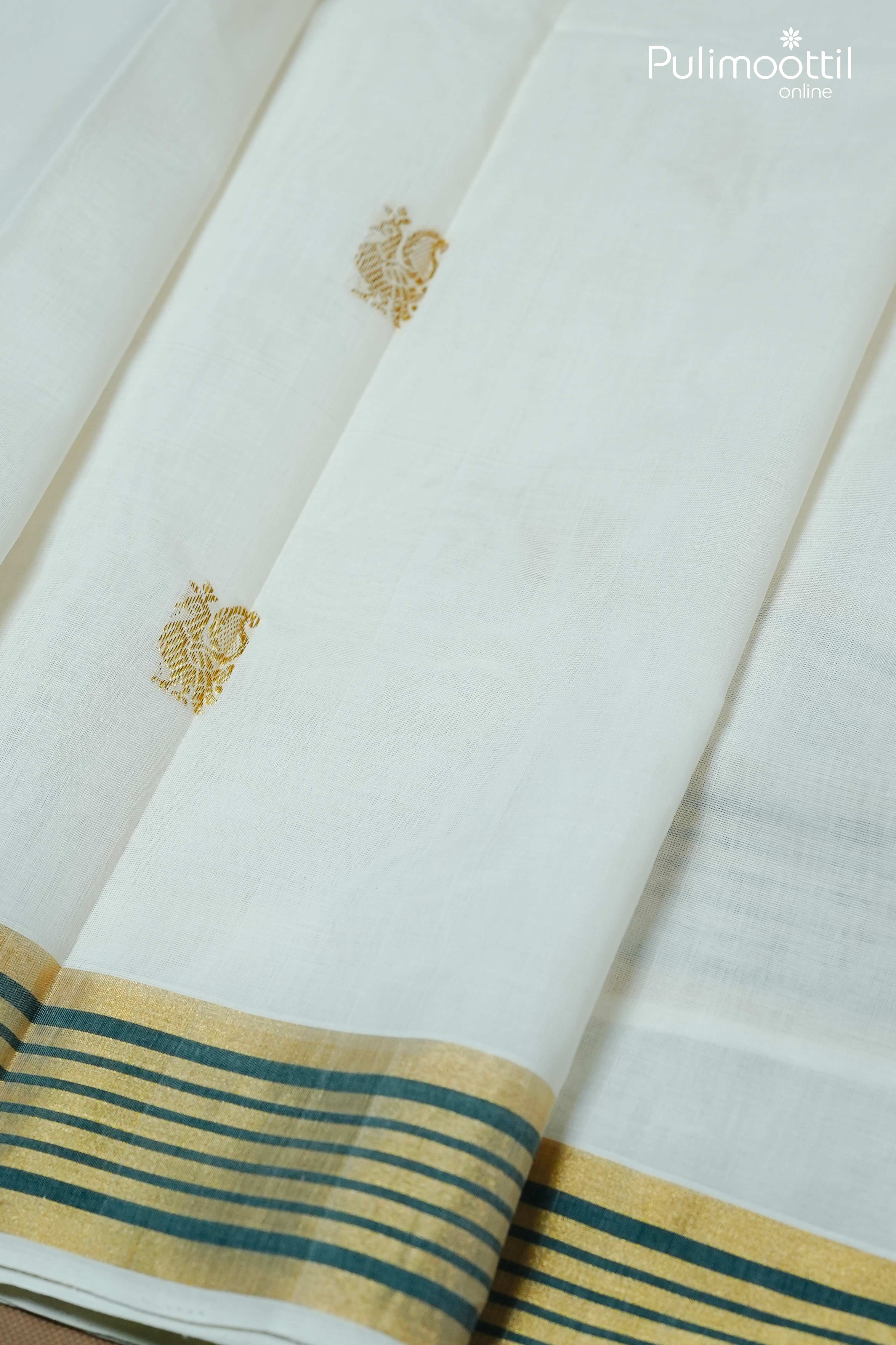 Close-up of cream colour Kerala set saree with golden zari peacock motifs and golden-green striped tissue border, highlighting fine weaving details.
