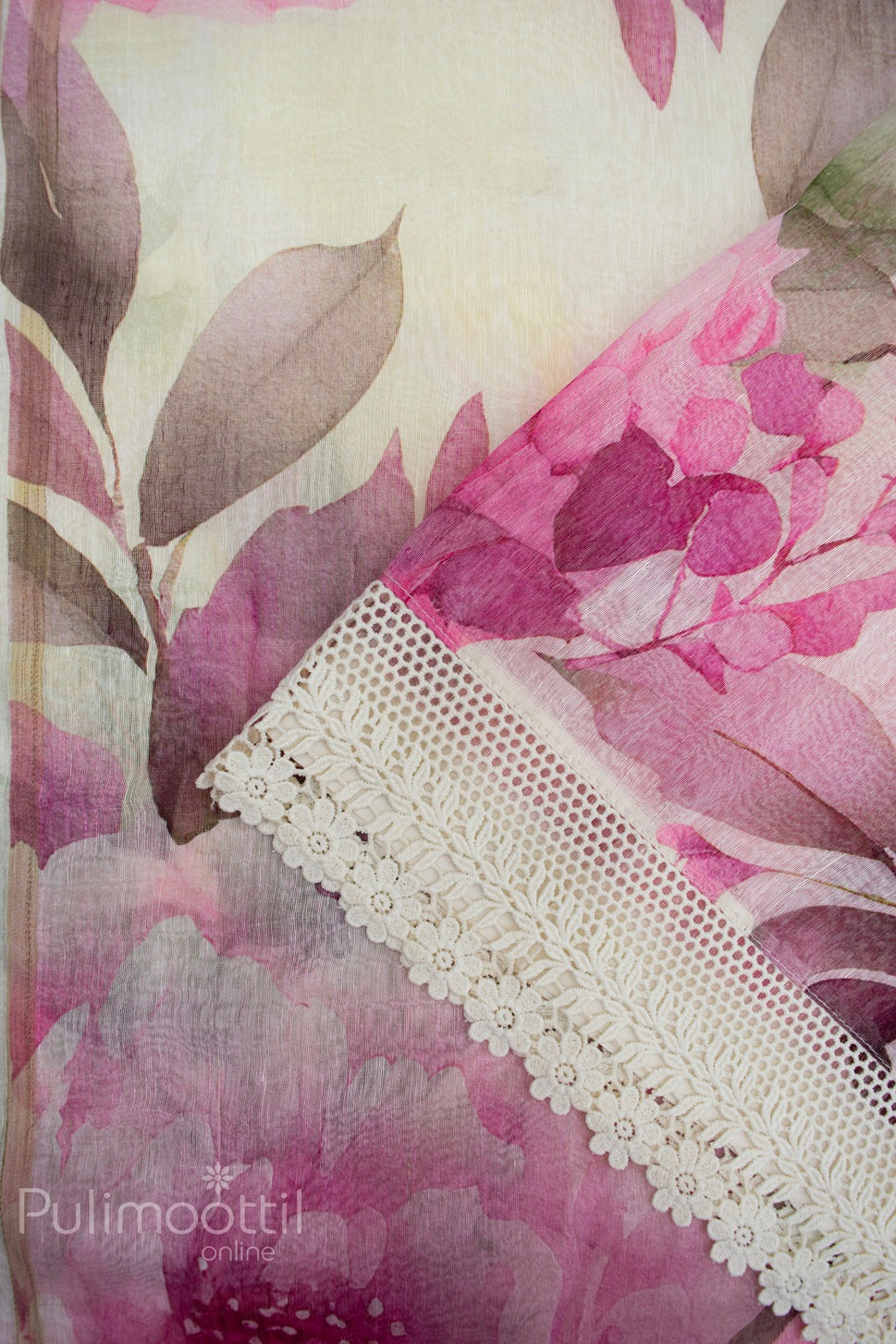 Cream linen saree with pink and mauve floral print and intricately embroidered Crosia lace border, showcasing soft texture and feminine elegance.