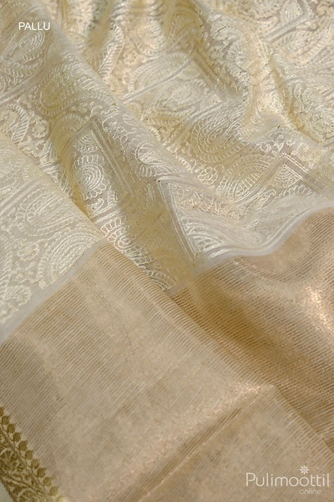 Close-up of cream net cotta saree pallu featuring elegant golden zari detailing and intricate mango floral thread embroidery.