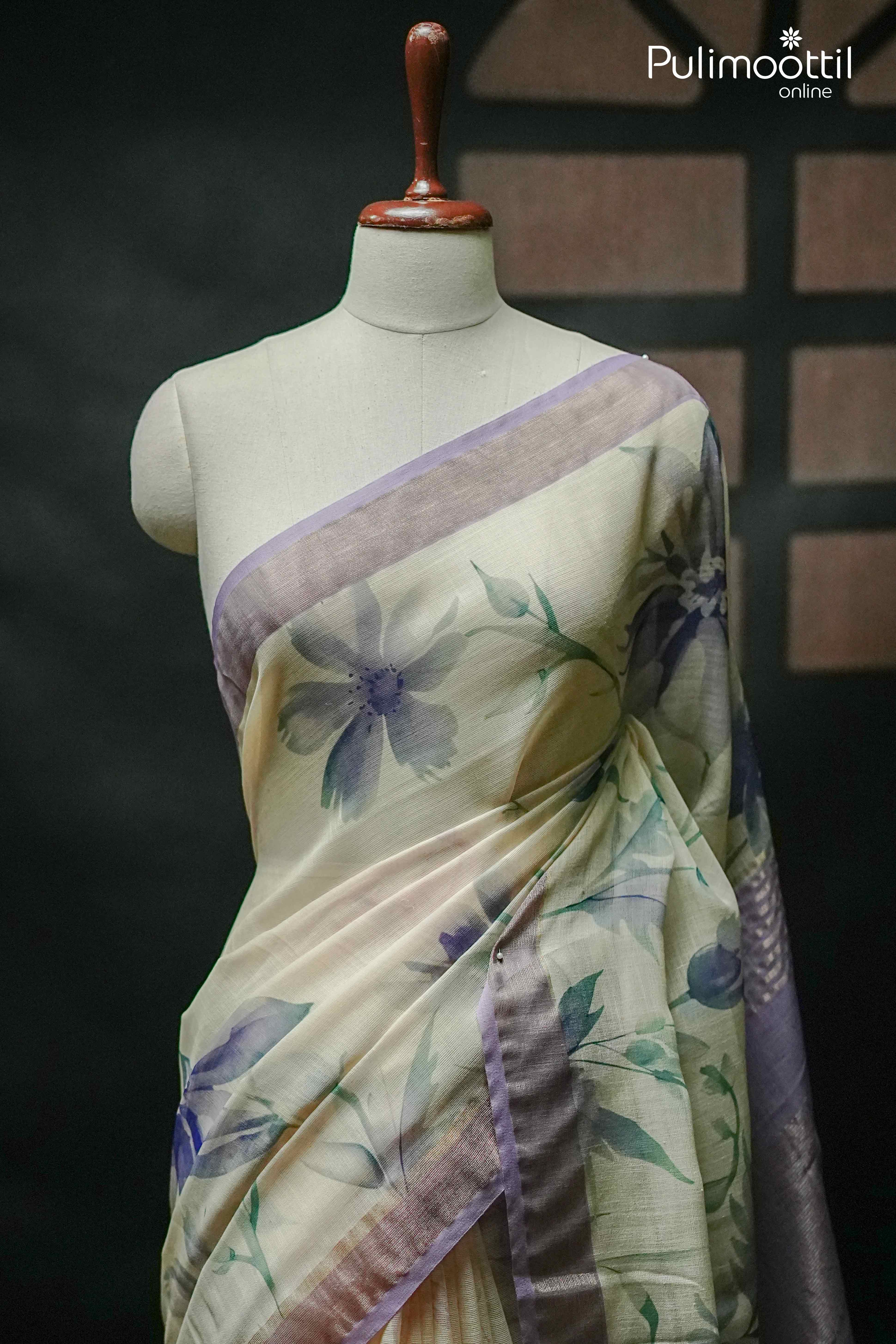 Elegant cream semi linen saree with lavender floral print and contrasting lavender border, draped on a mannequin – Pulimoottil Online