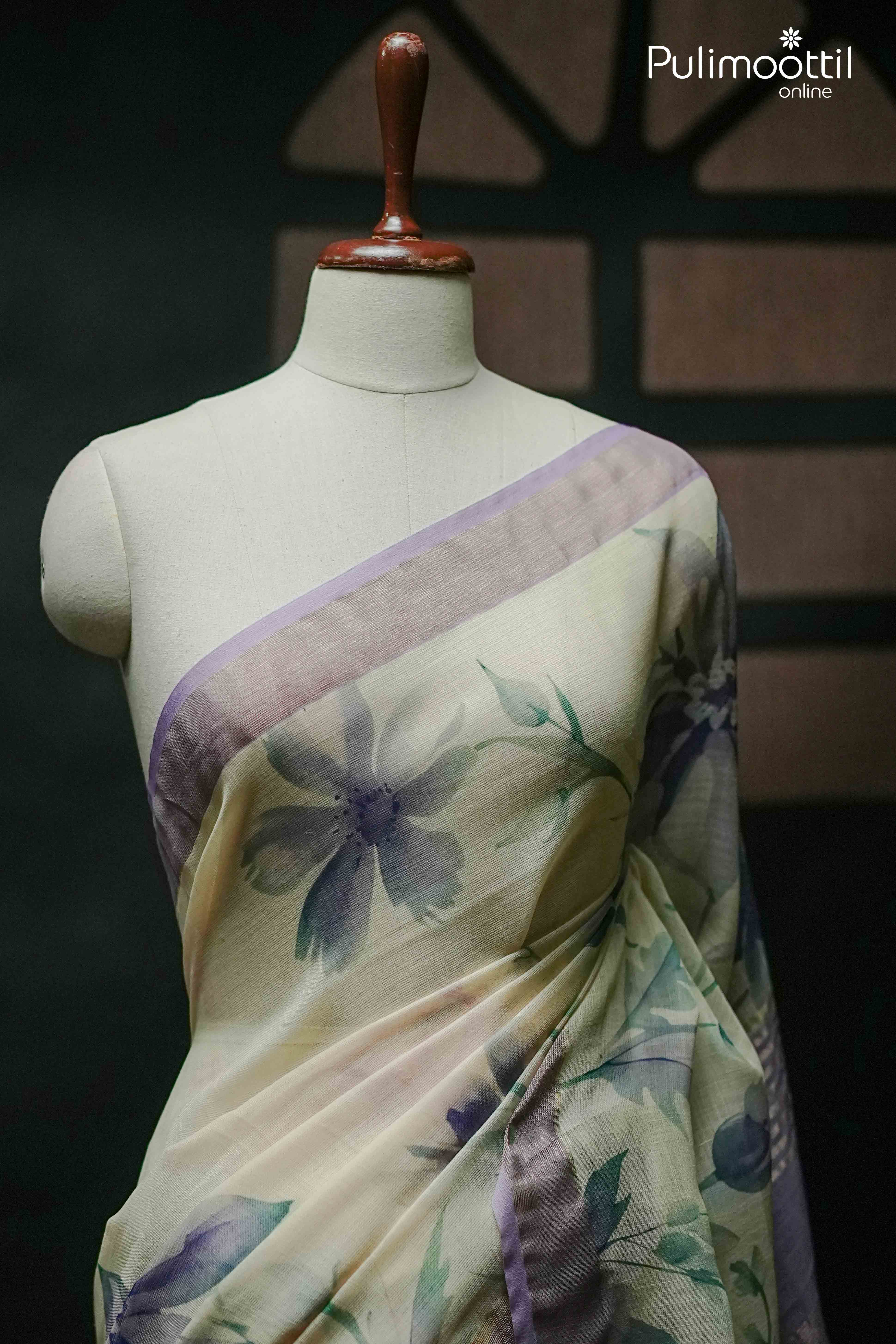 Cream semi linen saree with soft lavender floral print and contrast lavender border draped on a mannequin – Pulimoottil Online