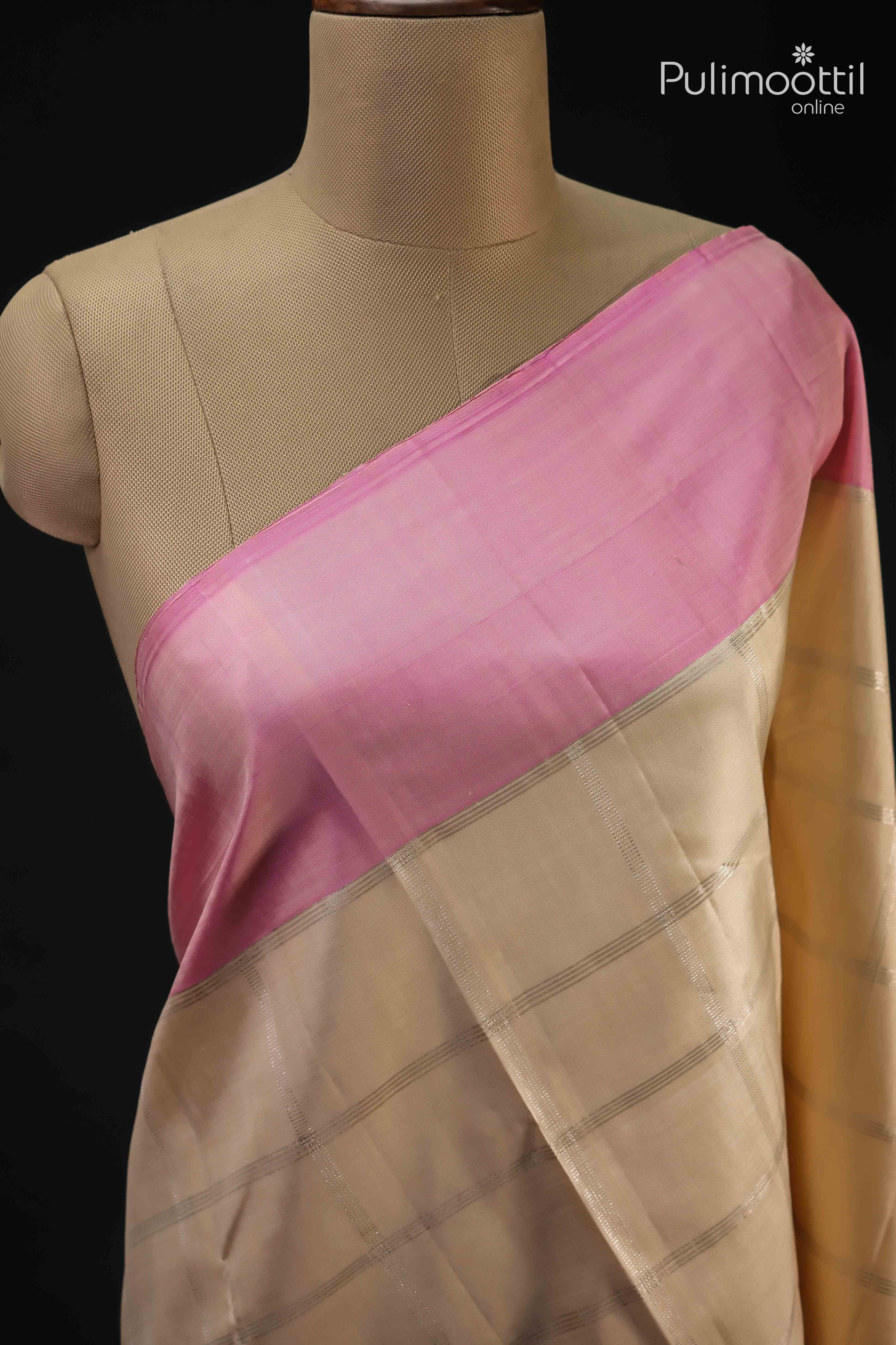 Cream colour pure Kanchipuram silk saree with silver checked design and contrasting soft pink border draped on a mannequin.
