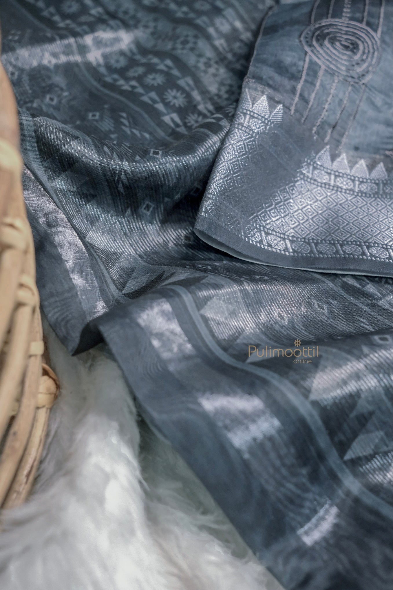 A full view of the saree displayed on a mannequin or draped for display. The graceful fall and shimmer of Chandari silk are visible, with intricate woven motifs.