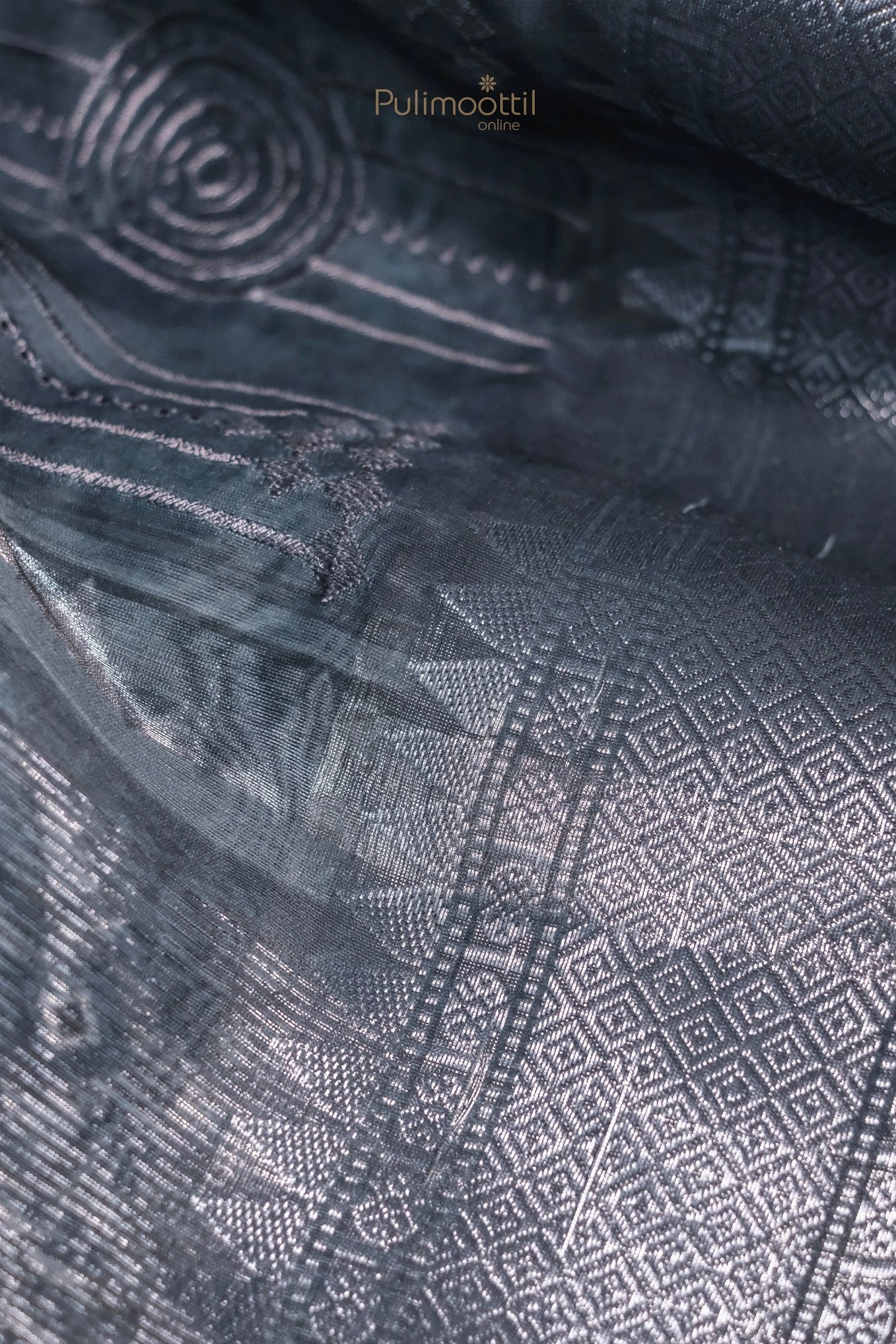 Possibly a lifestyle or model shot. The saree is worn and styled, showcasing how it looks when draped. You can see the elegant flow and sheen of the fabric.