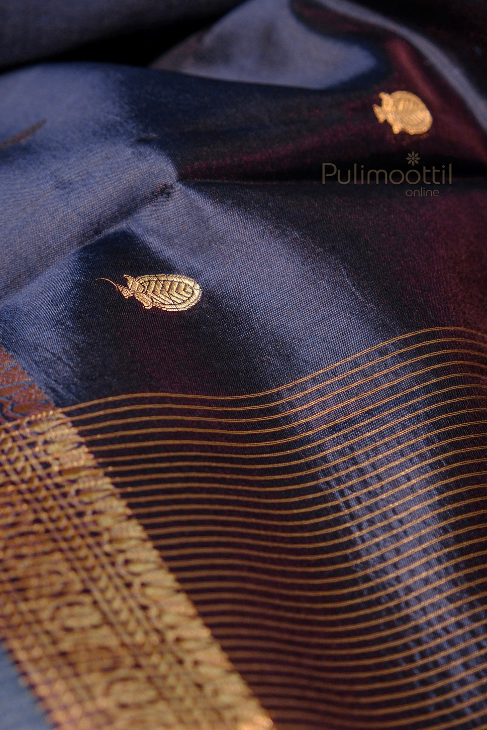 Detailed view of golden mango motifs woven on rich purple silk fabric with golden zari stripes and floral border.