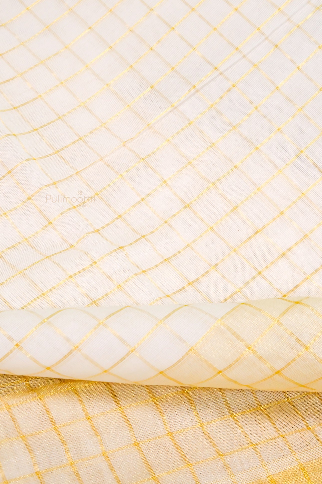 Detailed shot of Kerala kasavu mundu with golden thread grid pattern on cream-colored fabric