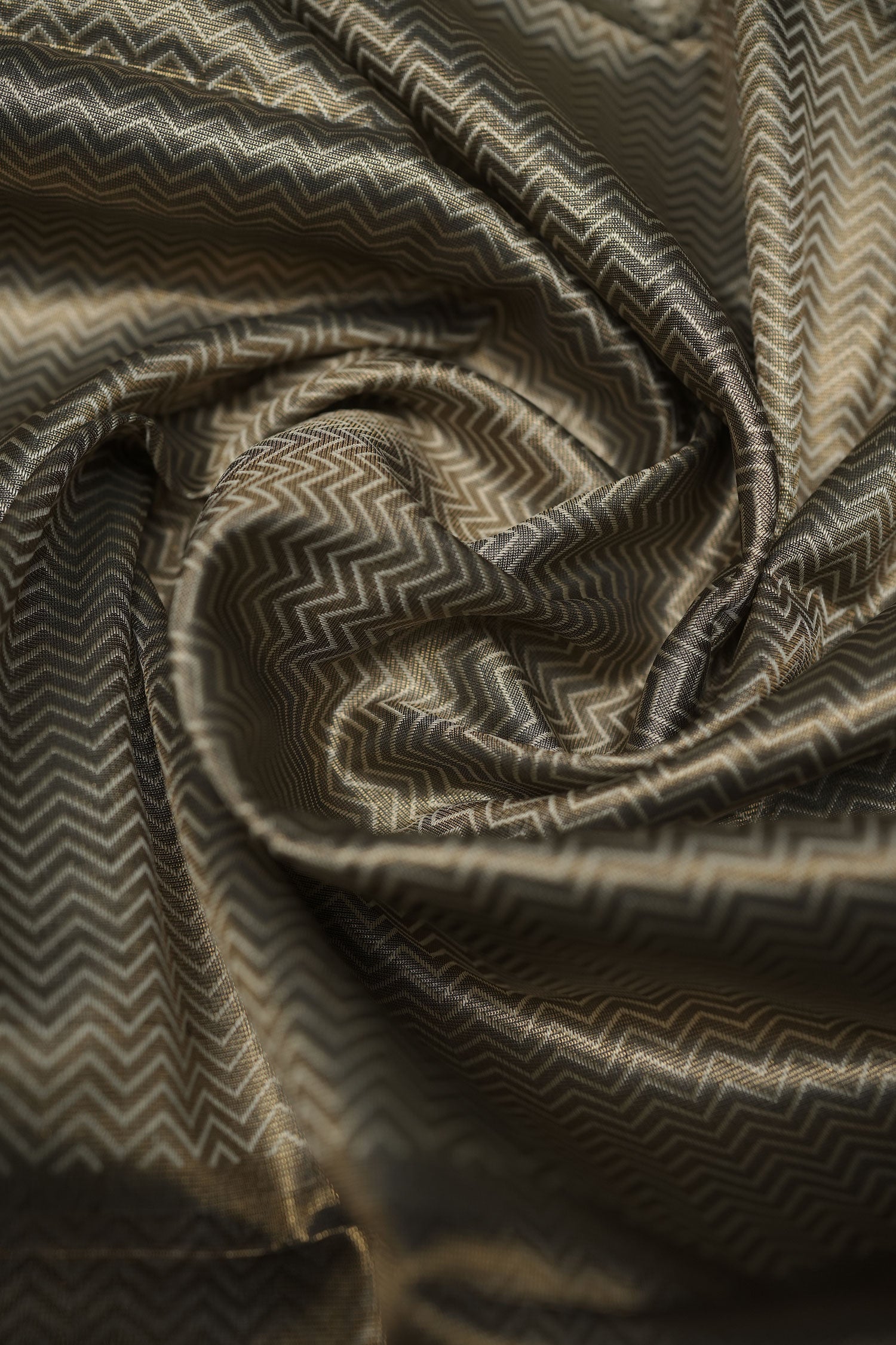 Gold-toned semi-silk blouse piece with subtle chevron jacquard weave, softly twisted to highlight texture and sheen.