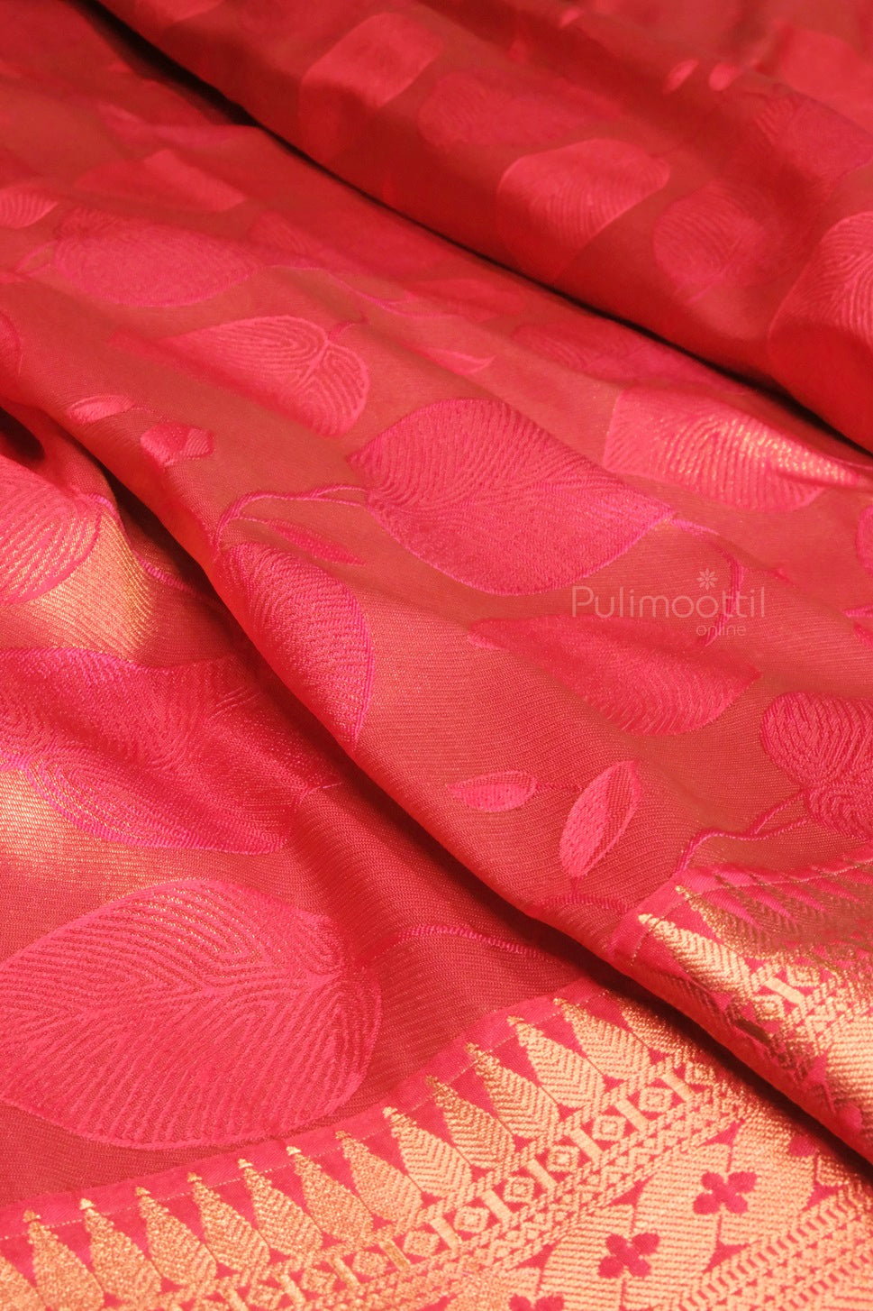 Back view of the bridal saree displaying the full drape and intricate gold zari weaving on the red silk fabric.