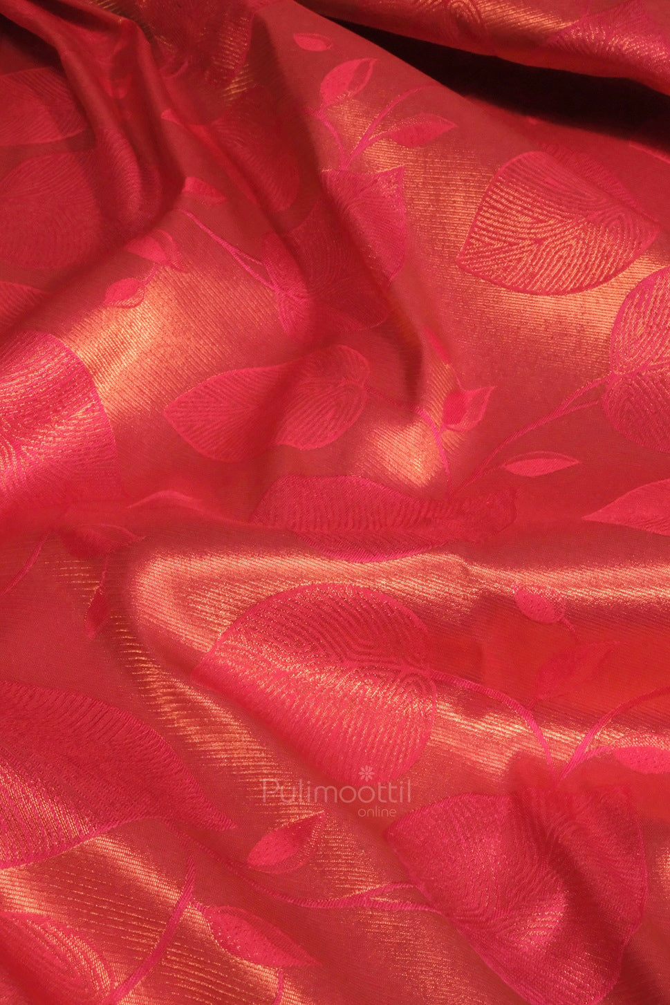 Detailed close-up of the saree’s pleats and fabric texture, emphasizing the rich golden zari patterns on red silk.
