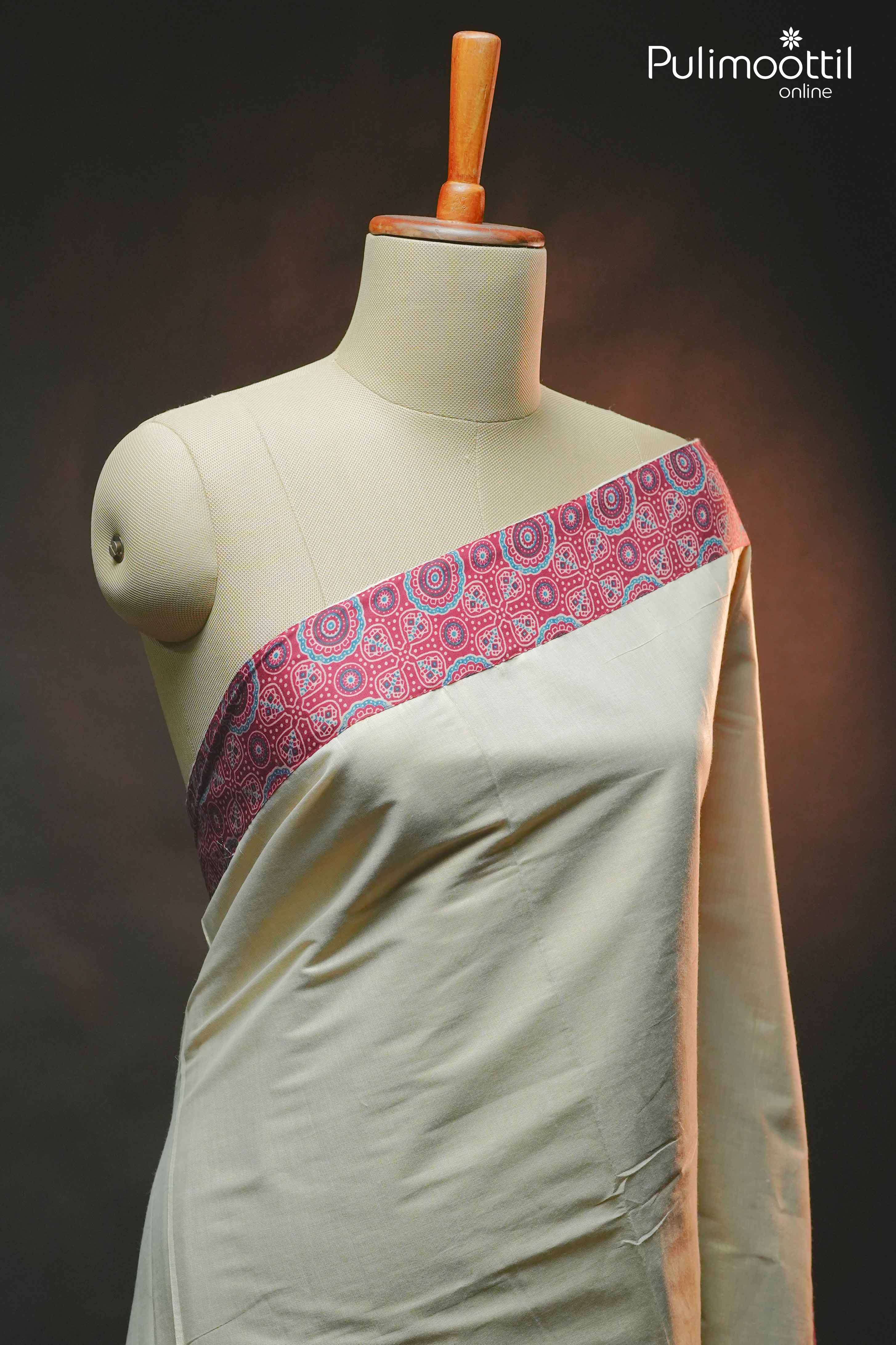 Golden tissue saree draped on mannequin, featuring contrast maroon Ajrakh printed border in a front angle view.