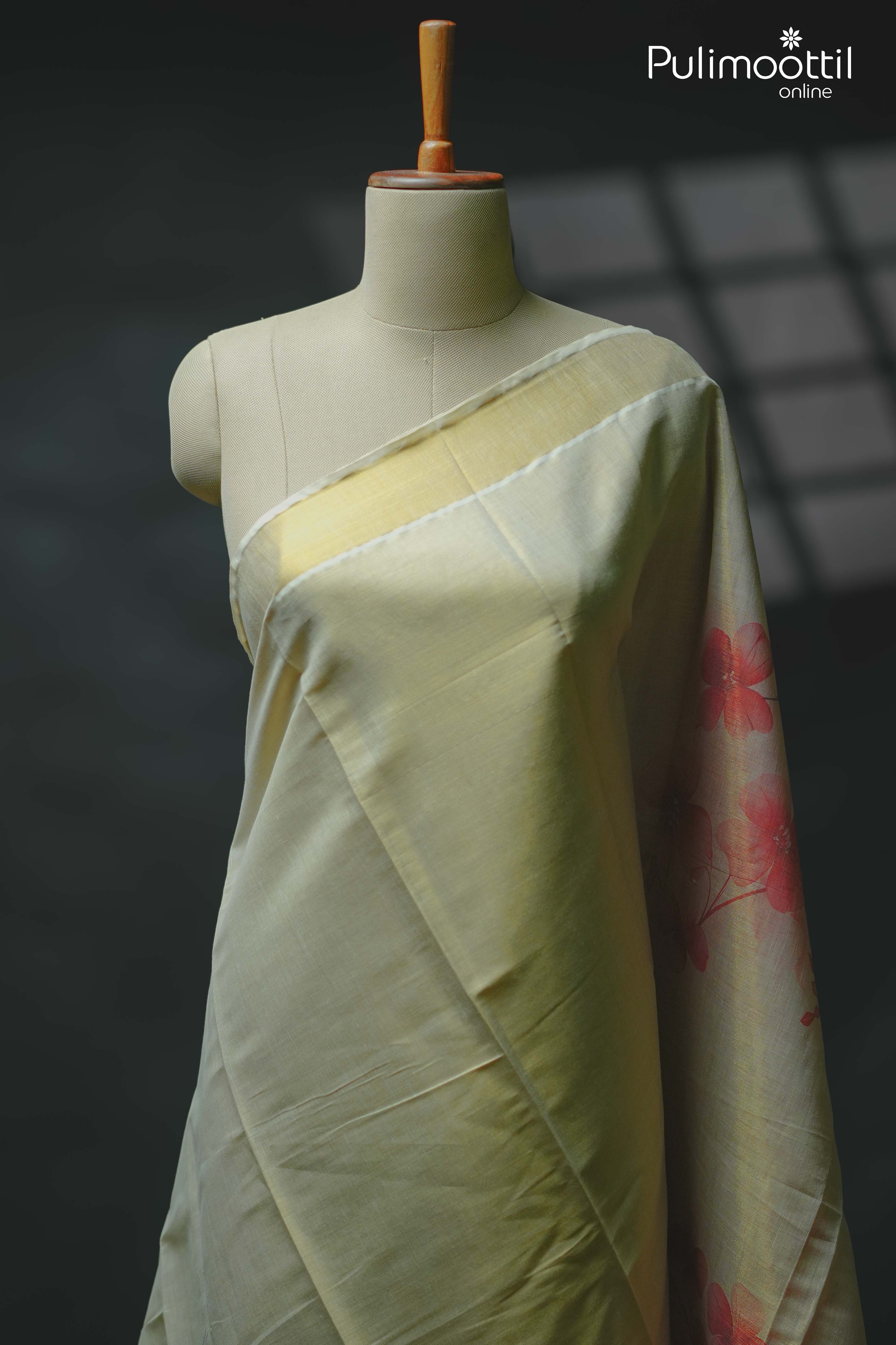 Golden tissue floral printed saree draped on mannequin, featuring soft gold-toned body with red floral prints on the pallu – Pulimoottil Silks