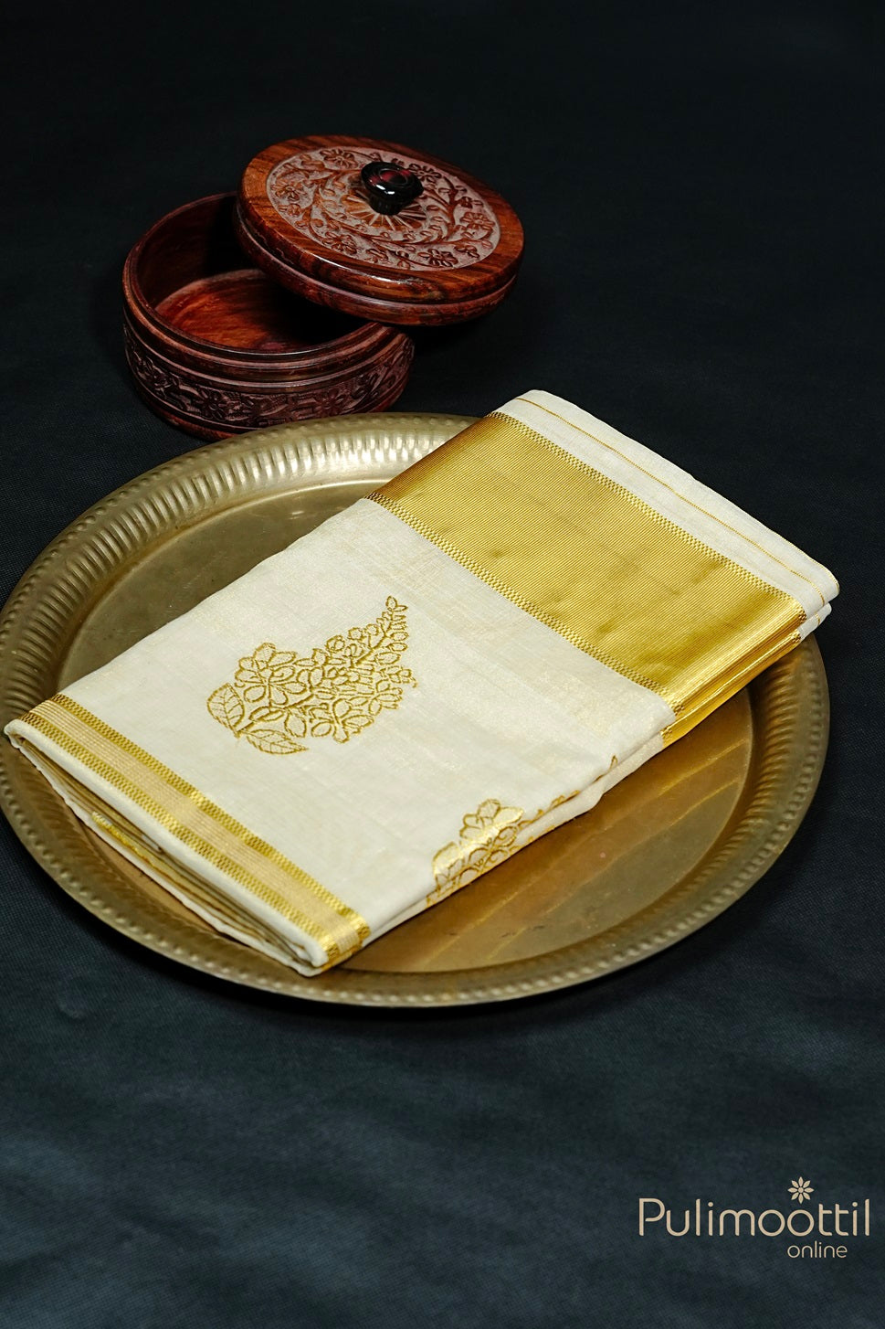 Golden Tissue Kerala Traditional Handloom Saree with golden zari floral buttas and tissue border, neatly folded on a decorative plate.