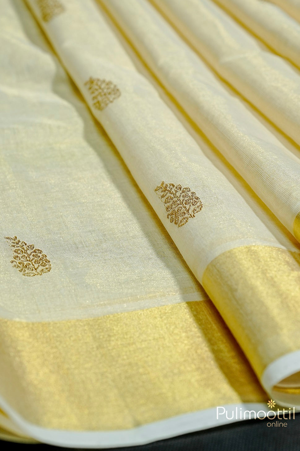 Golden Tissue Kerala Traditional Handloom Set Saree with golden zari floral buttas and a tissue border.