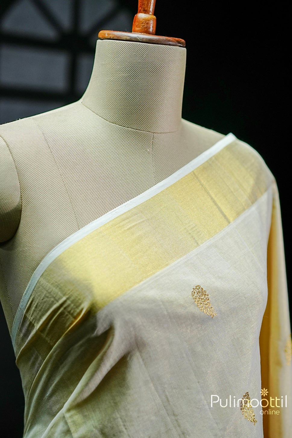 Golden Tissue Kerala Traditional Handloom Set Saree draped on a mannequin, showcasing the golden zari floral buttas and tissue border.