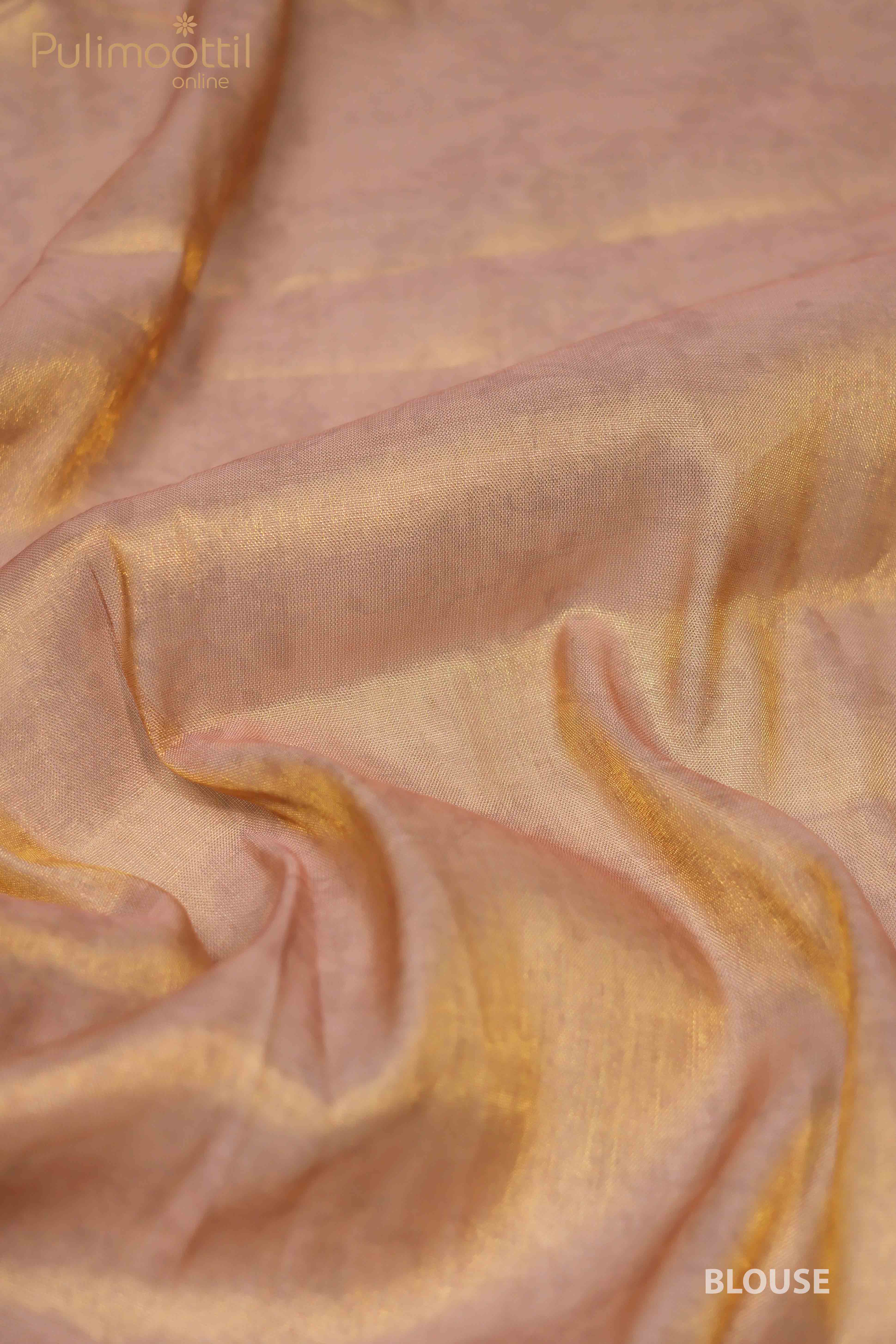 Close-up shot of the golden tissue fabric of the blouse, showing its soft and smooth texture with a light pinkish-gold hue, capturing the subtle shine and delicate folds of the fabric.