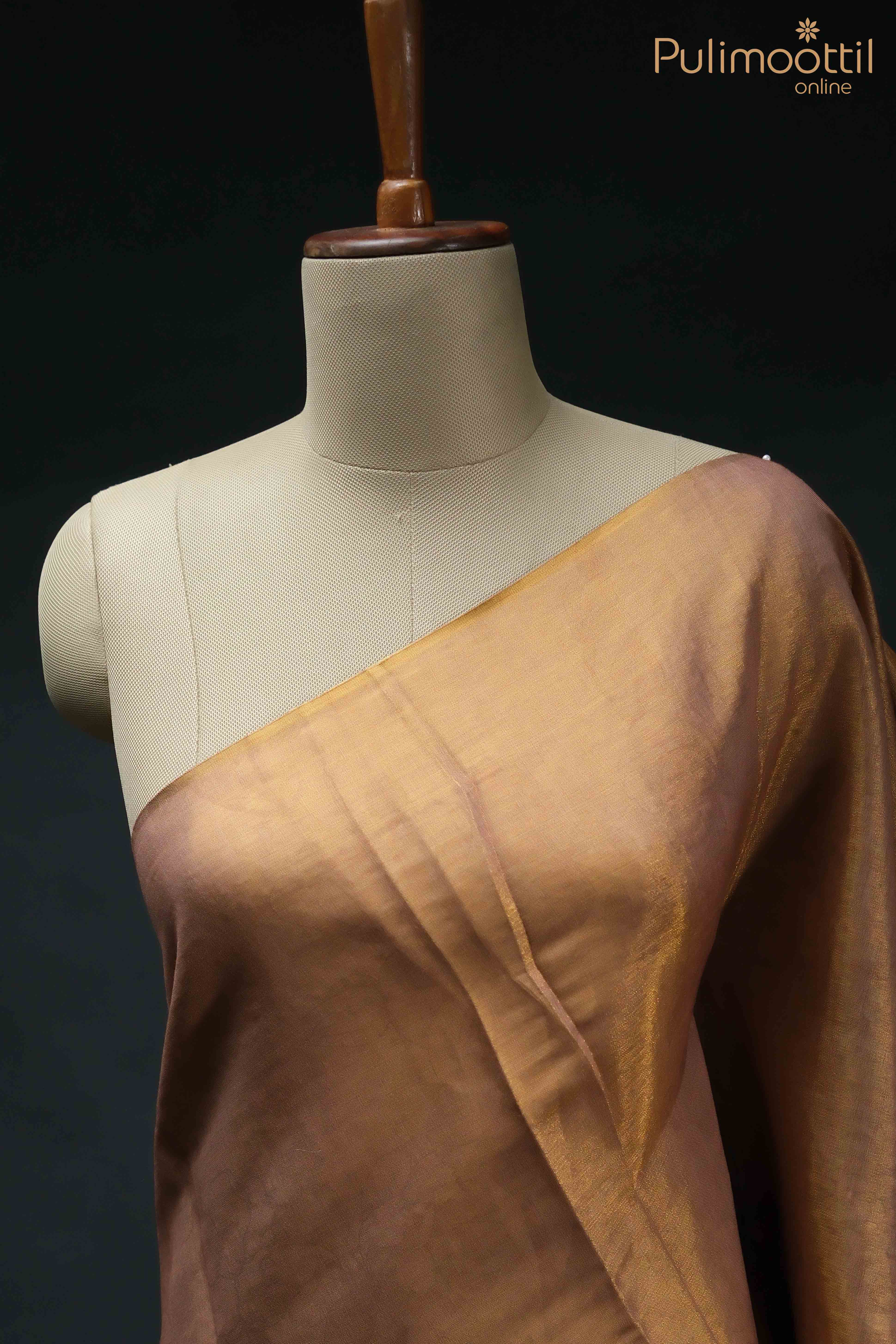 Golden Tissue Onam Kerala Traditional Set Saree draped over a mannequin, showcasing its smooth texture and lustrous shine, with one side revealing the soft, golden hue and no border.