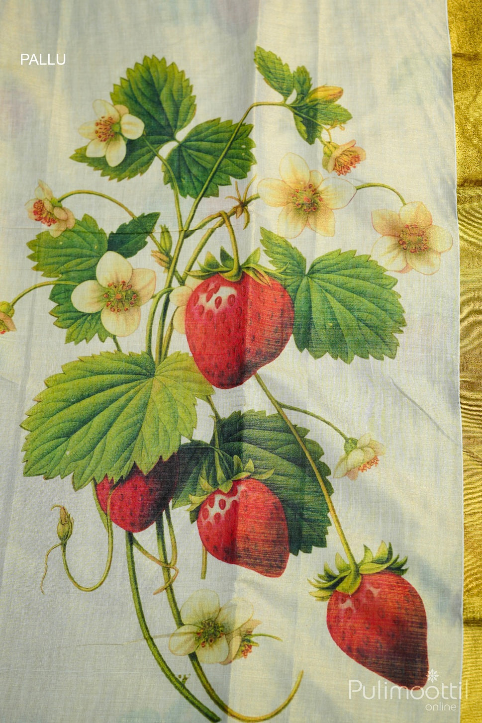 Close-up of saree pallu with four red strawberries on branching stems, small white strawberry flowers, and green leaves near a golden kasavu border.
