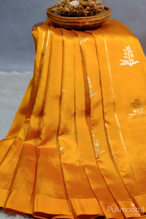 Golden Yellow Mango Saree with Geometric Pattern Lines and Zari Floral Design, Draped Elegantly with a Basket of Dried Flowers.
