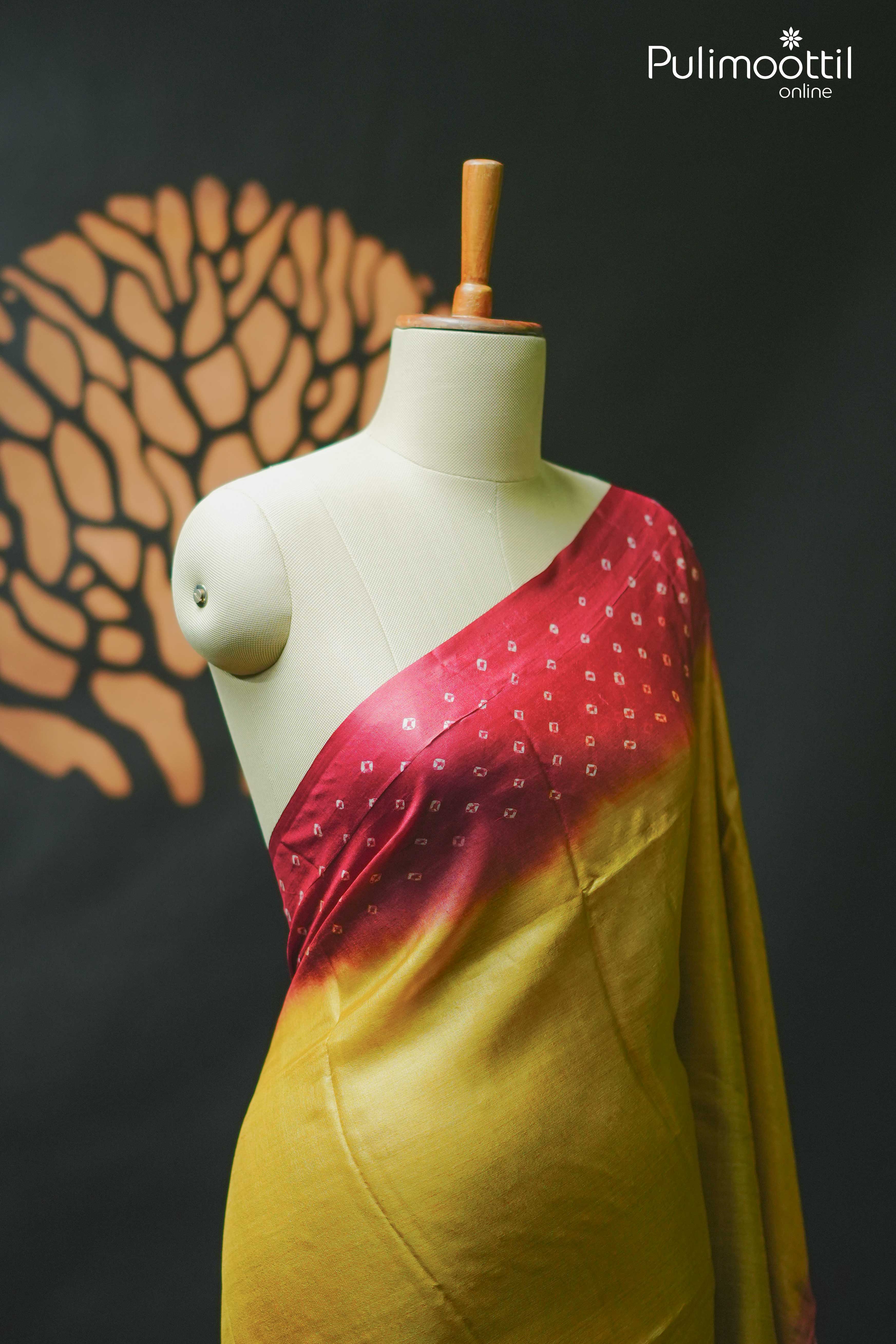 Golden yellow Tussar silk saree displayed on a mannequin, featuring a red tie-dye Chungidi pattern on the upper portion, ideal for festive occasions.