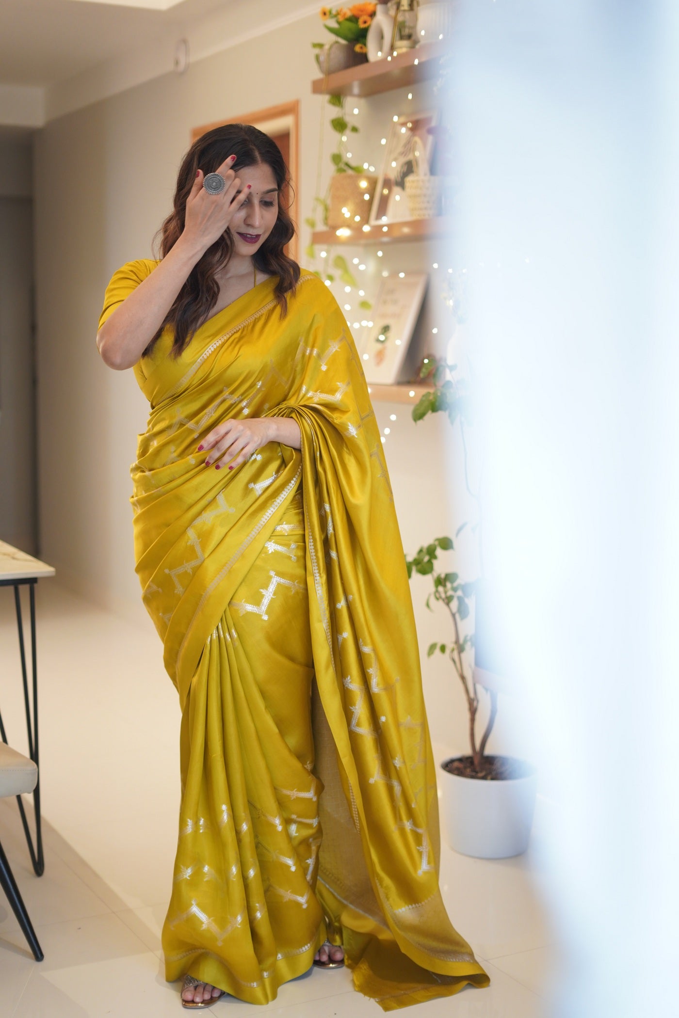 Mid-shot of woman smiling in green mango silk saree with elegant hand jewelry.
