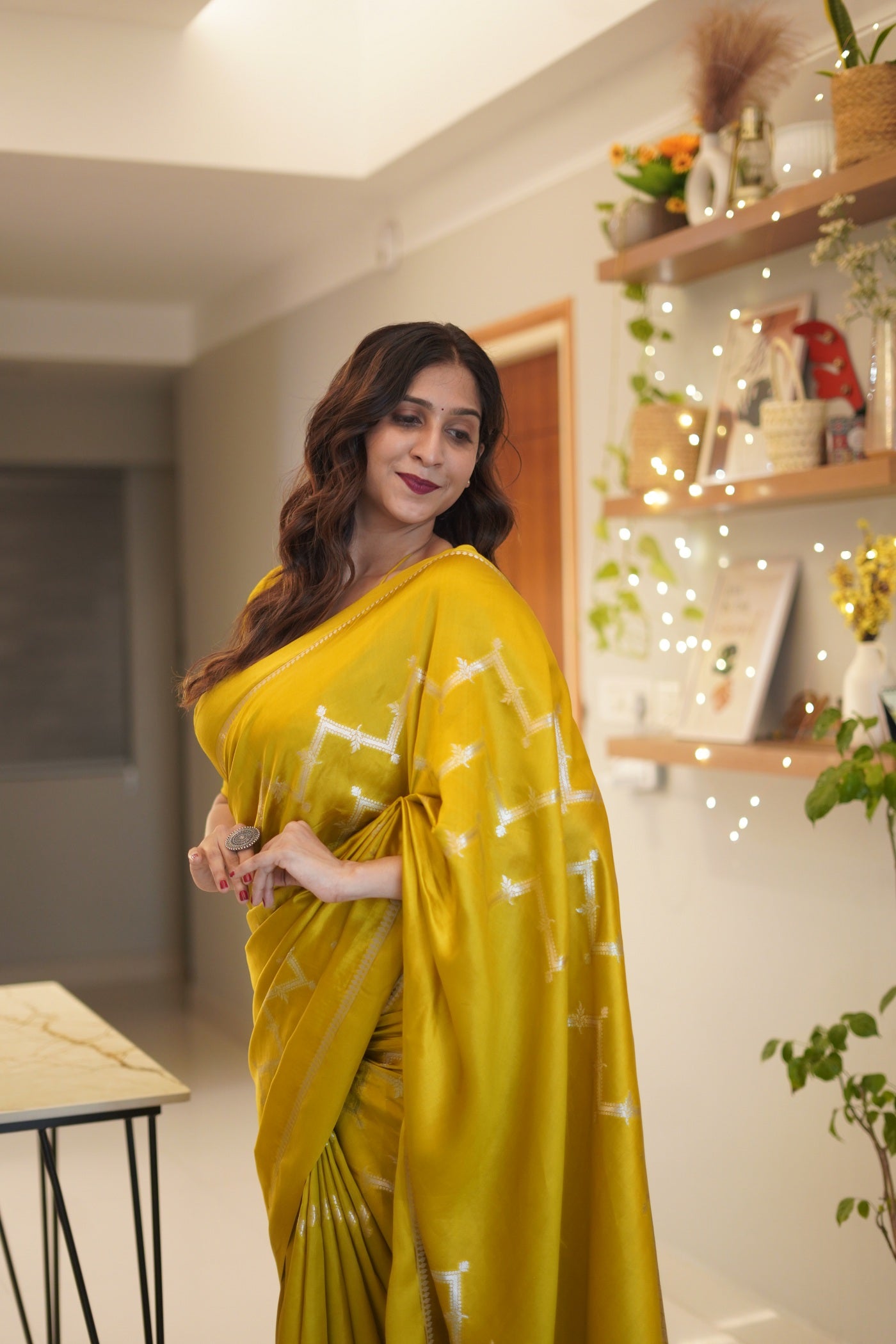 Side pose of woman in green mango silk saree highlighting pallu design.