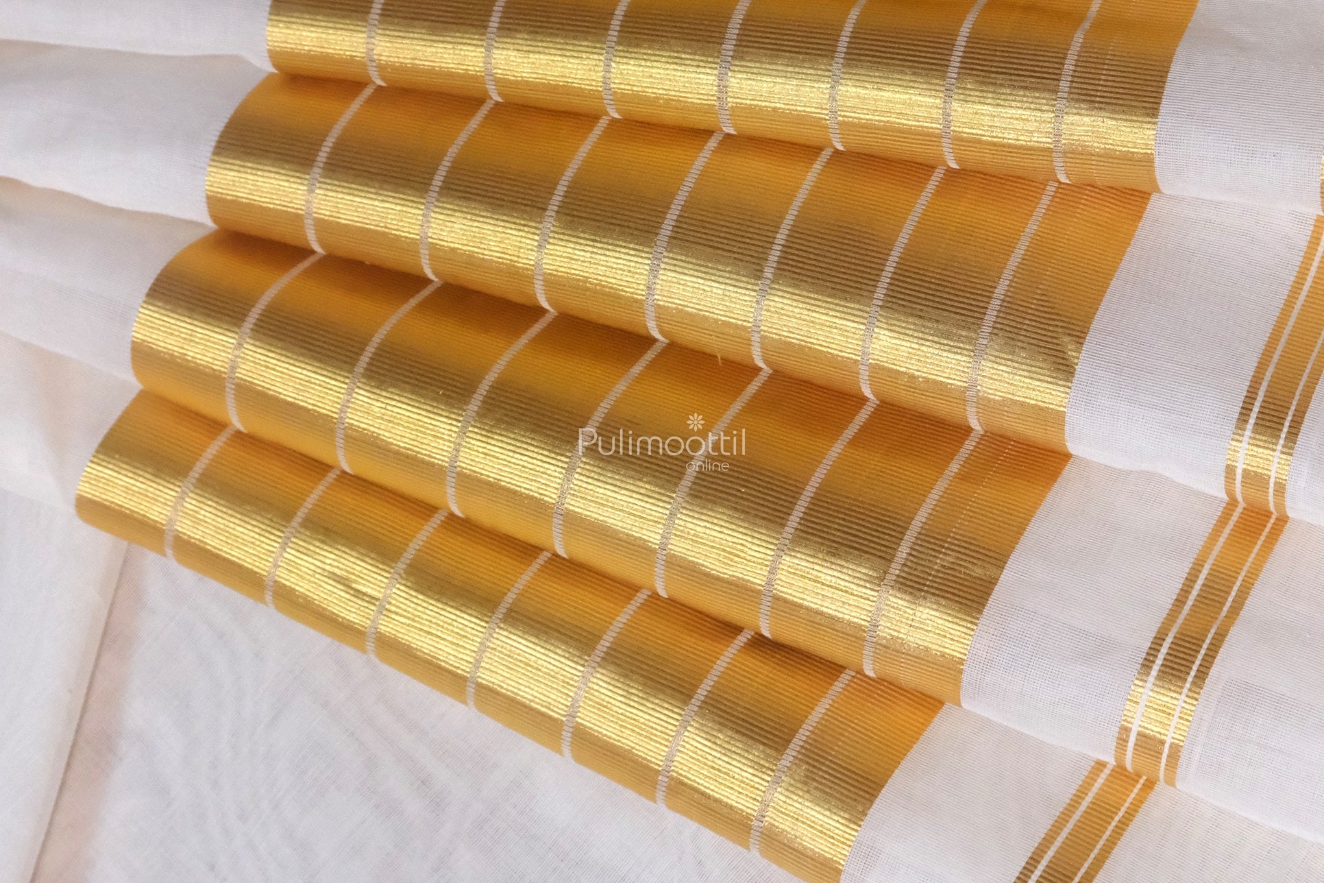 Close-up of traditional Kerala tissue saree with golden zari border and elegant white body