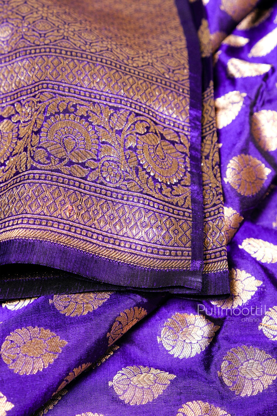 Detailed view of heavy golden zari floral and paisley woven border on purple pure silk Banarasi saree.