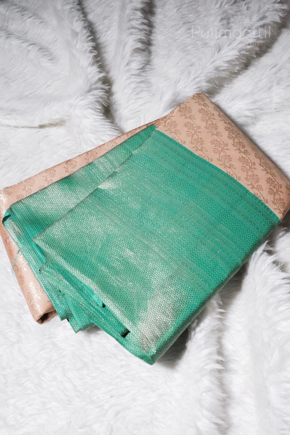 ivory cream Kanchipuram brocade saree laid flat, showing jungle green brocade border and subtle gold floral motif on body