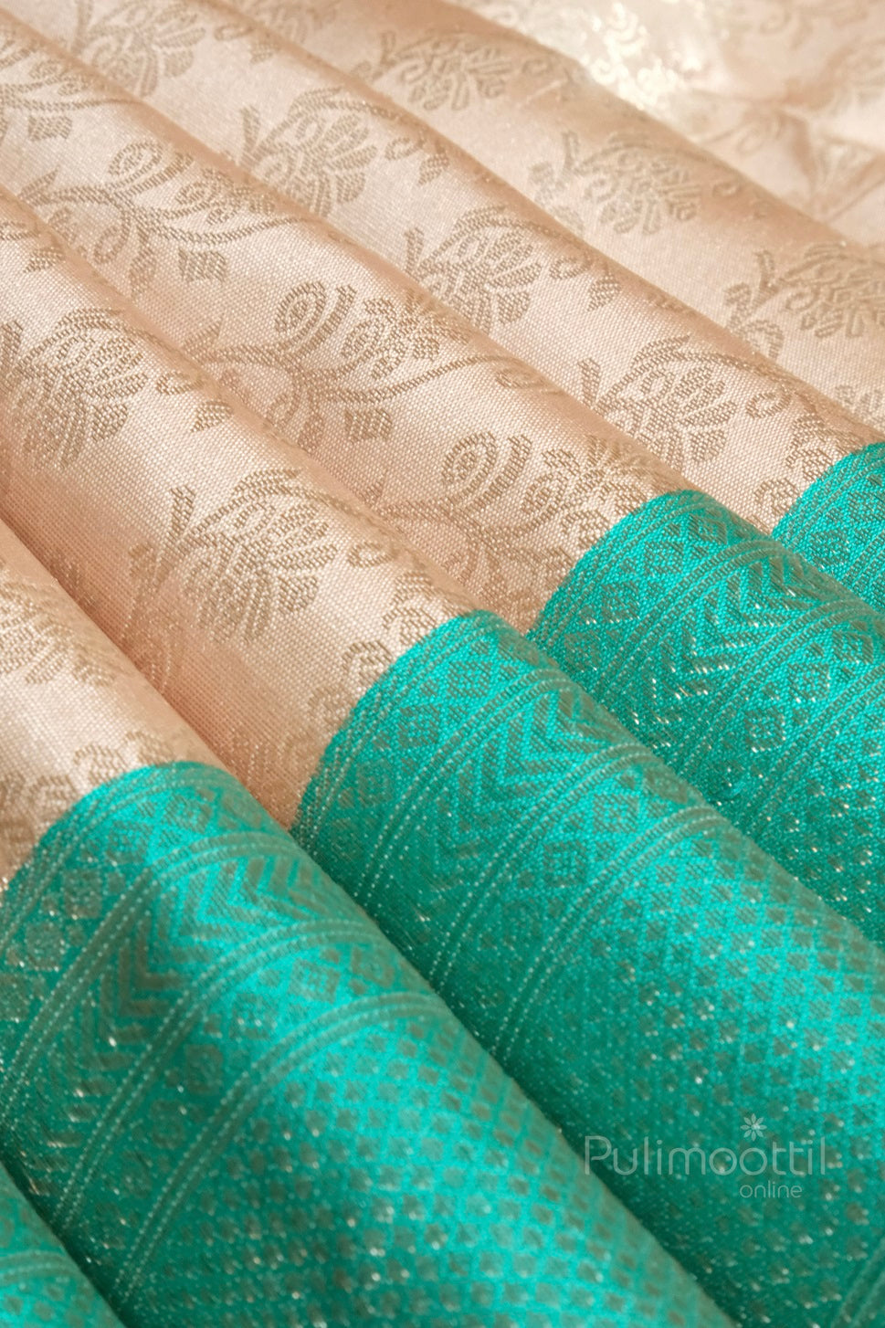close-up of ivory cream brocade silk with light gold floral motifs and rich jungle green brocade border