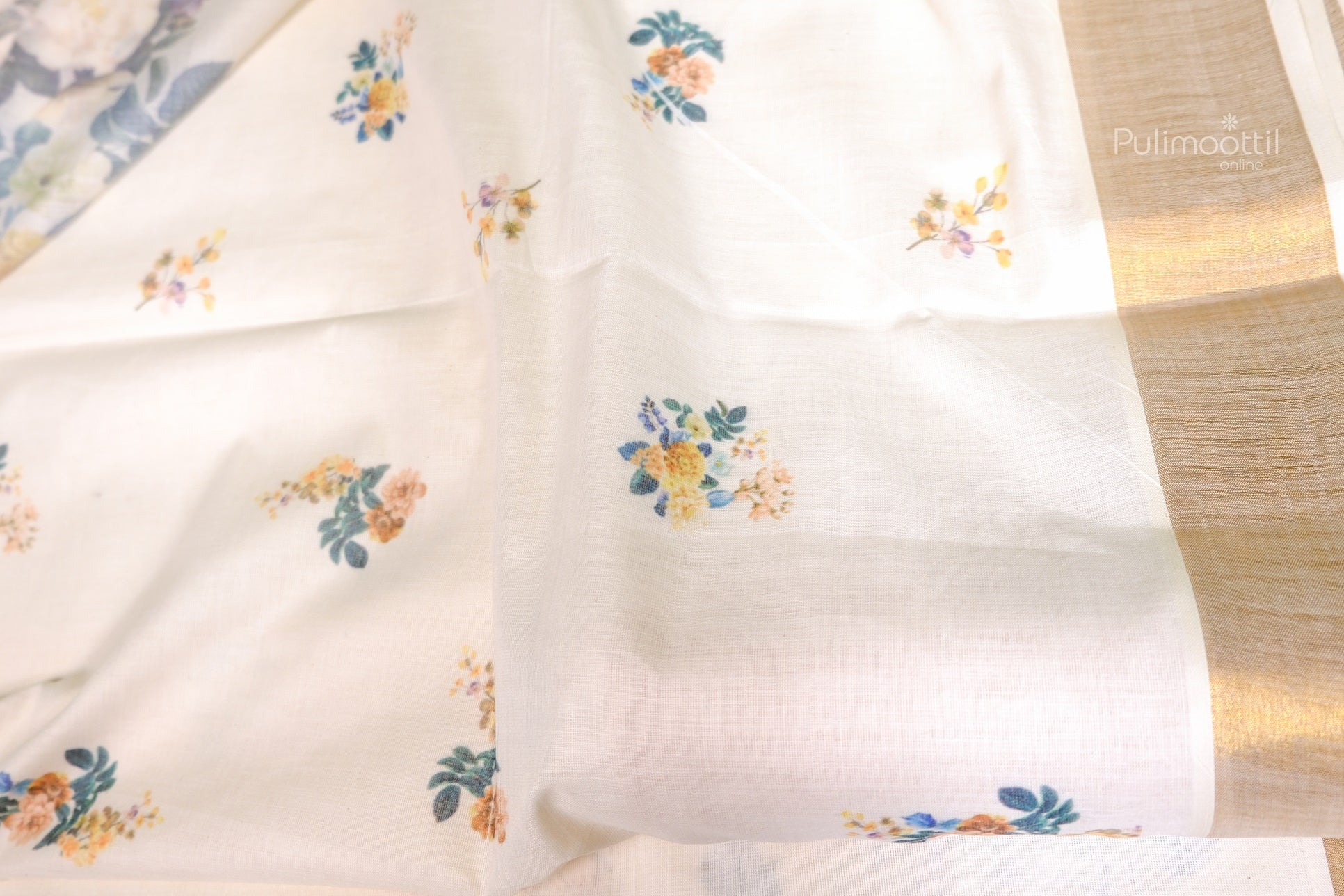 Kerala cotton tissue saree with small scattered floral motifs and subtle gold border, suitable for traditional Onam sarees and festive wear online.
