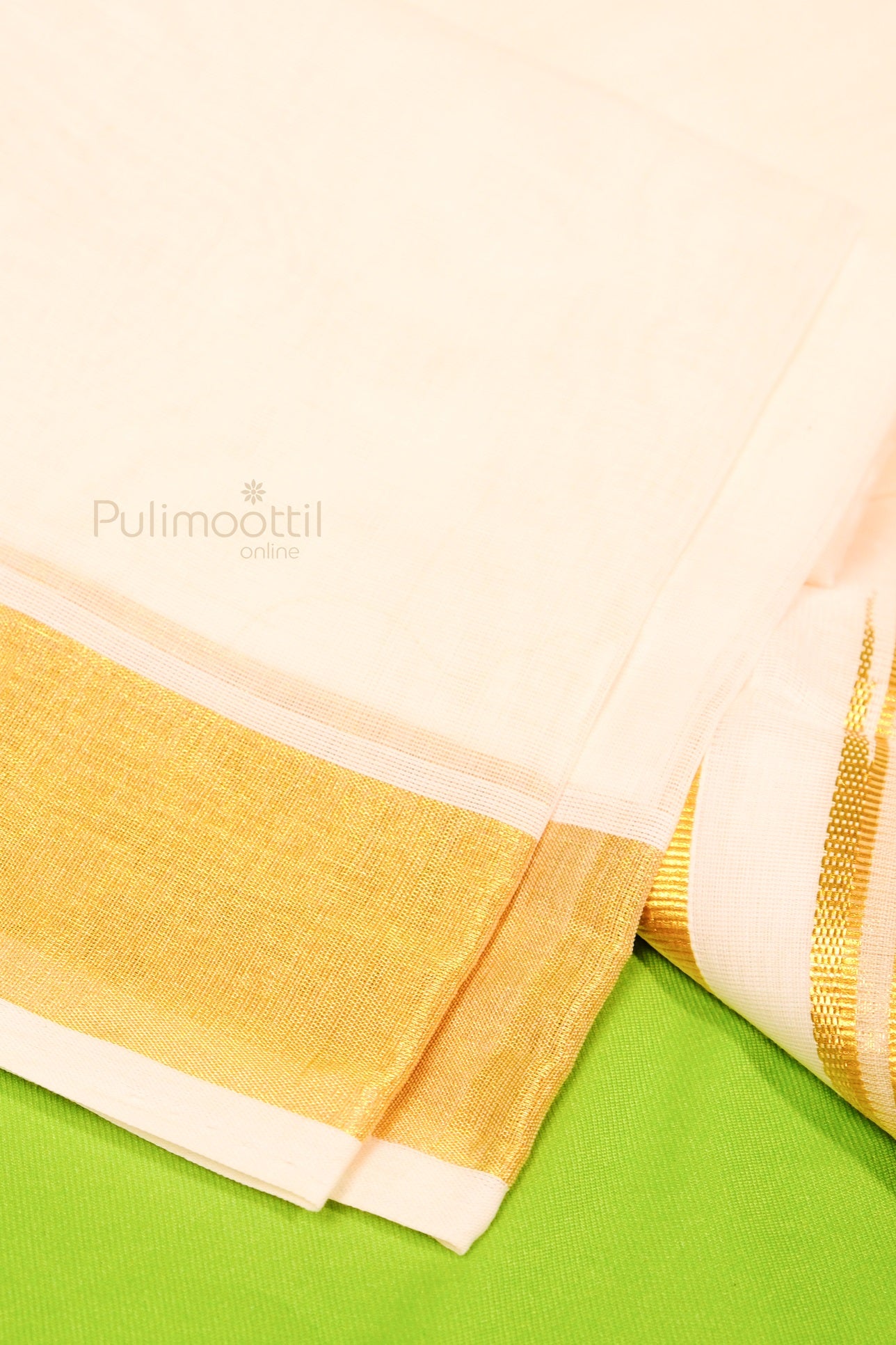 Close-up of Kerala kasavu mundu showing fine golden border on cream handloom cotton fabric
