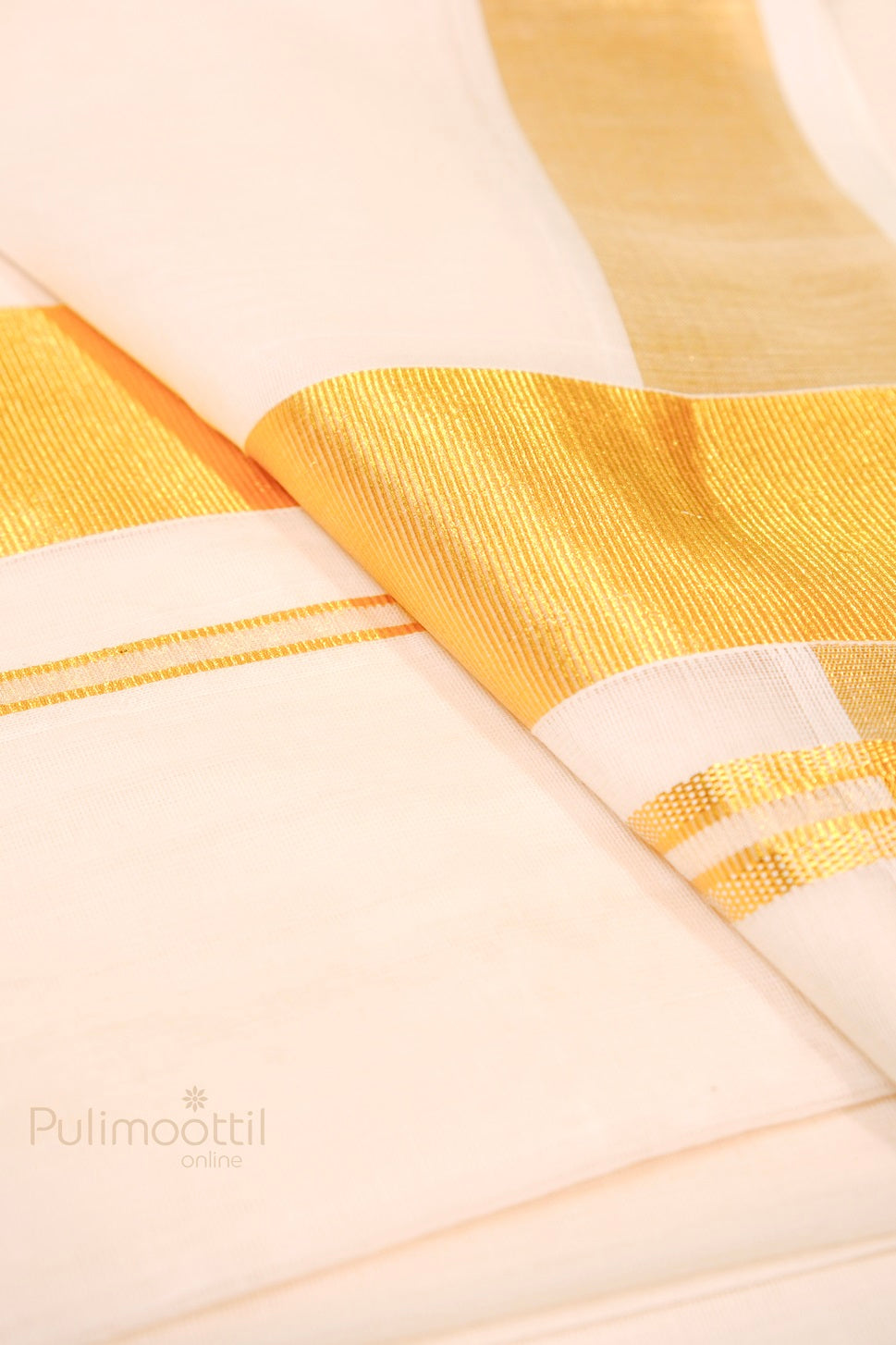 Kerala kasavu mundu displayed with shimmering golden zari detail on smooth cream cotton fabric