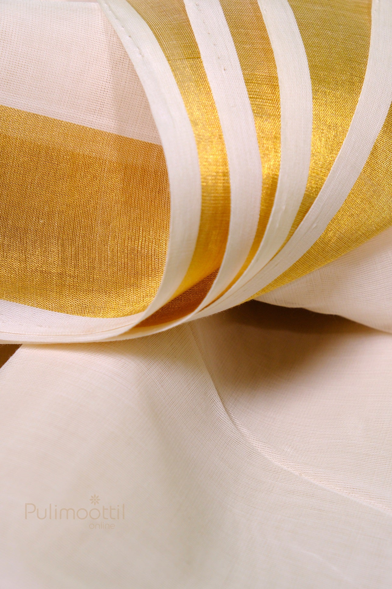 Flowing Kerala kasavu mundu showcasing intricate golden zari work on traditional white handloom fabric