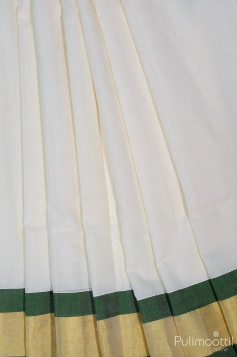 Kerala traditional handloom saree in ivory white with green thread work and golden tissue border — elegant pleats showcasing festive Onam attire.