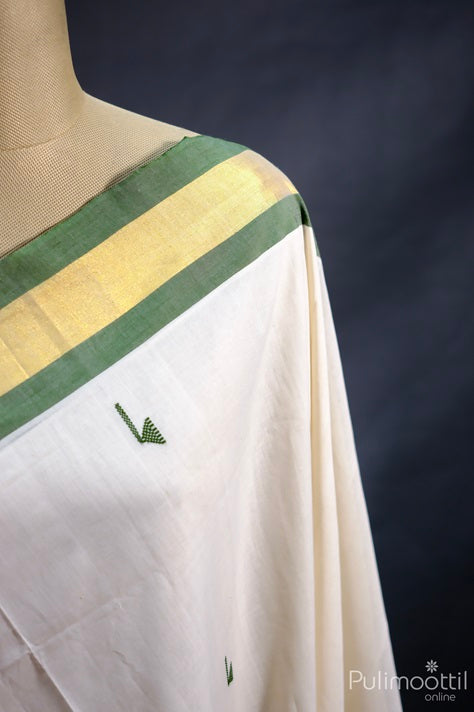 Ivory Kerala handloom saree with golden tissue border and green stripe — features traditional thread butta design, ideal for Onam celebrations.