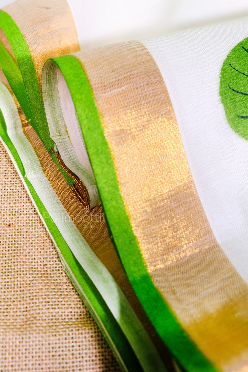 Detailed view of green and golden border on Kerala saree with bold lotus leaf motifs – Onam wear collection.