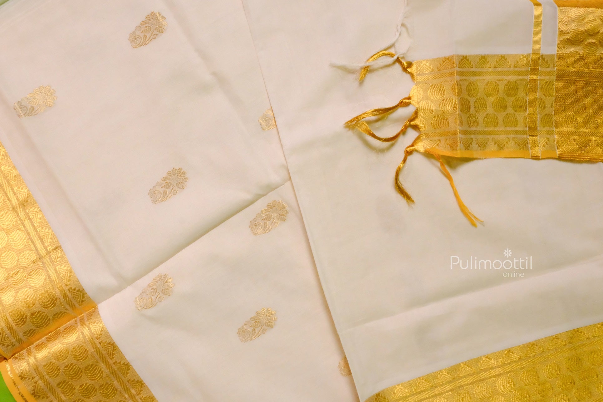 Complete Kerala saree layout with golden pallu, zari borders, and scattered floral buttas on a soft off-white background.