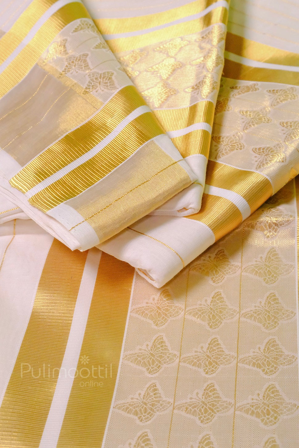 Elegant Kerala kasavu saree draped to showcase its full length with golden zari borders and delicate butterfly embroidery near the pallu.